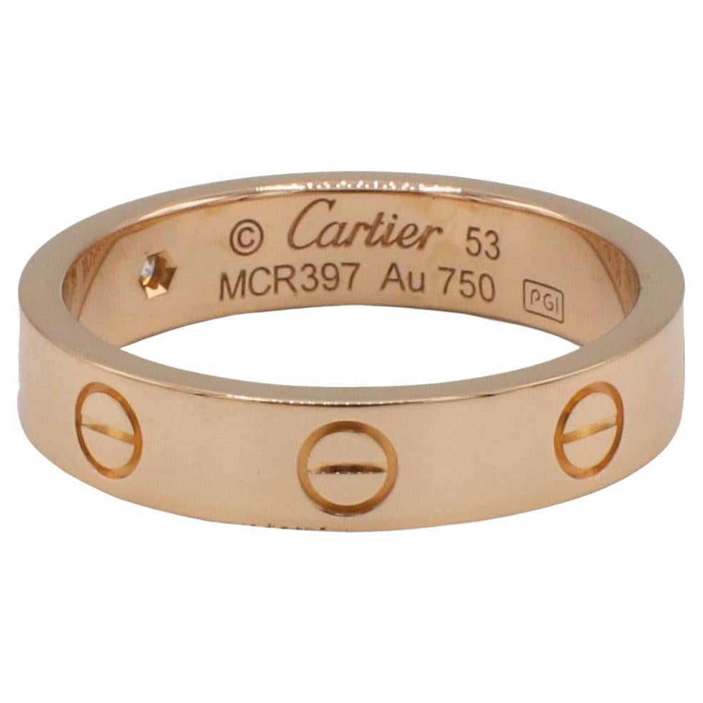 Cartier Love 18 Karat Rose Gold ein Diamant Ehering, kleines Model No. 

Metall: 18k Roségold
Gewicht: 4.72 Gramm
Einzelhandel: $2,410 USD
Diamant: 1 runder Diamant .02 Karat D VVS2
Größe: 53 (6.25 US)
Breite: 4 mm
Anmerkung: Schachtel, COA,