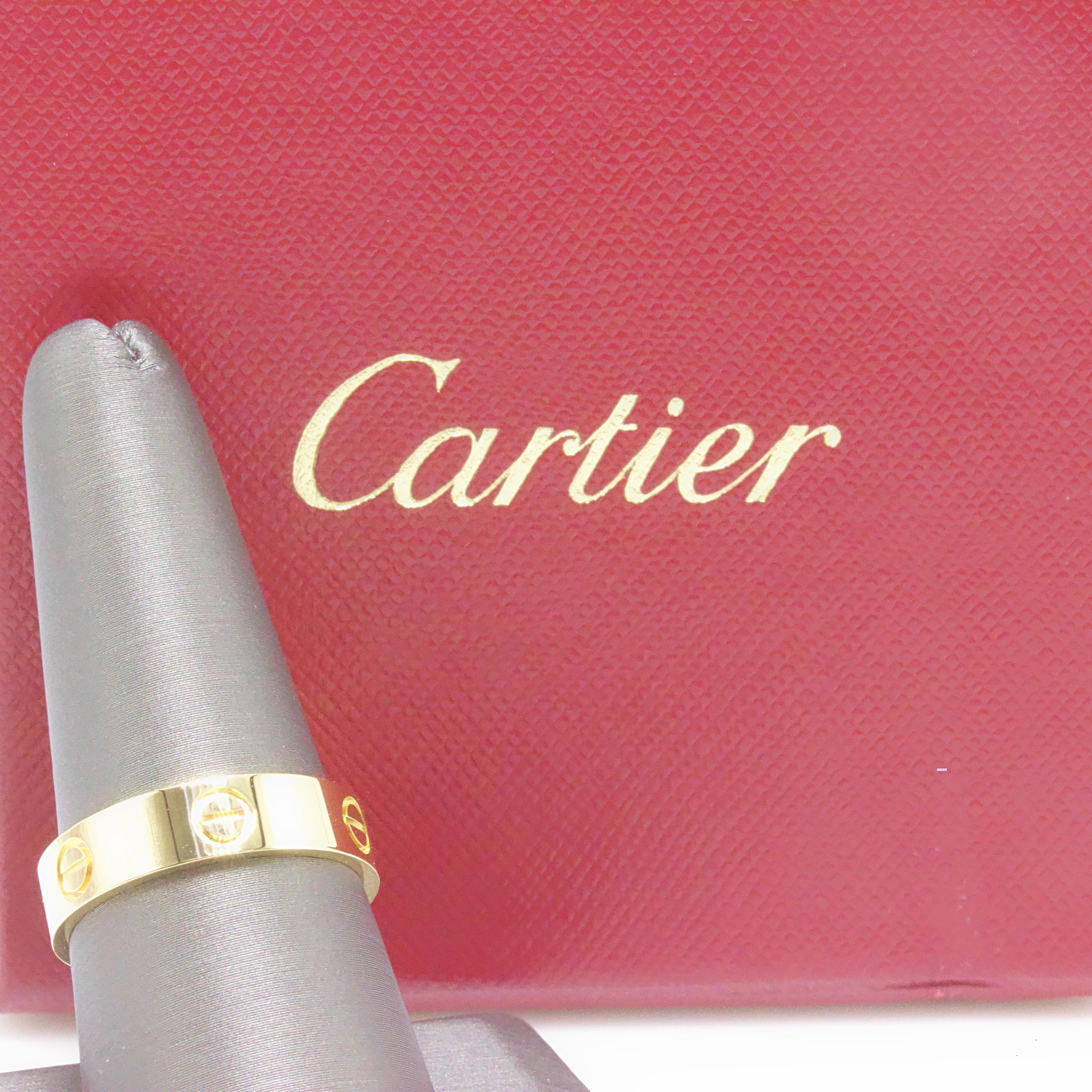 Cartier 

Style: LOVE Band Ring
Serial Number: DVM***
Metal: !8Kt Yellow Gold
Ring Size: 9.5 US / 61 French
Hallmark: 