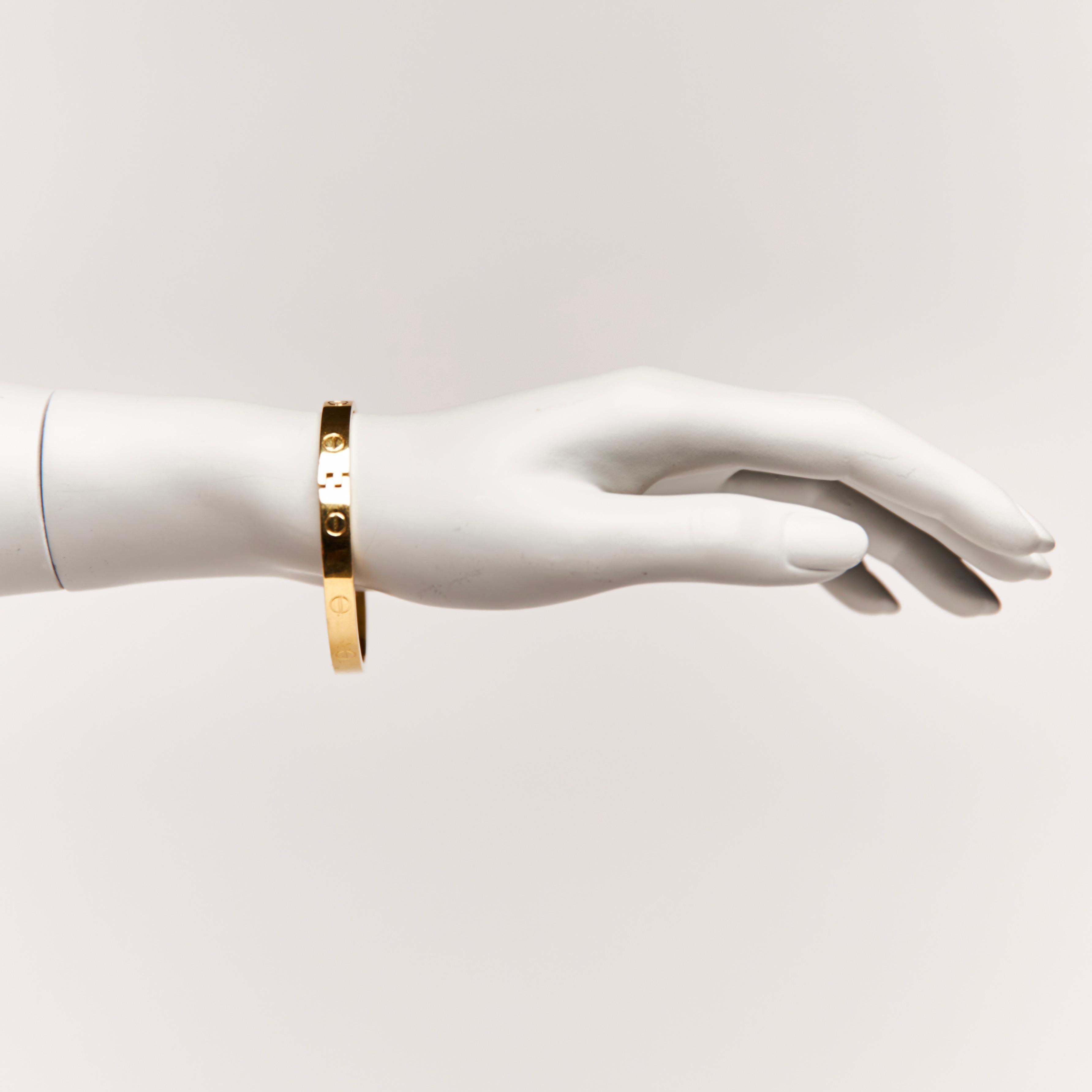 This is the “Love” bracelet by Designer Aldo Cipullo.  In 1970 Aldo Cipullo and Cartier made this with Charles Revson.

BRAND: Aldo Cipullo & Cartier X Charles Revson
ITEM CODE: 01970
MATERIAL: Gold electroplated
MEASURES: 2.75” x 2”
CIRCUMFERENCE: