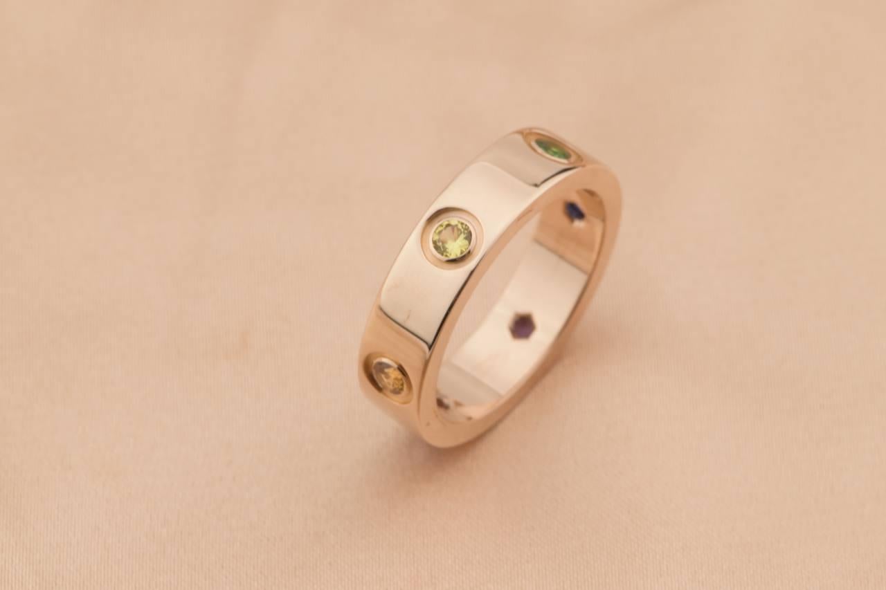 LOVE ring, 18K rose gold, set with 1 pink sapphire, 1 blue sapphire, 1 yellow sapphire, 1 green garnet, 1 orange garnet, and 1 amethyst. 

Dandelion Antiques Code	AT-1079
Brand	                                Cartier
Model	                          