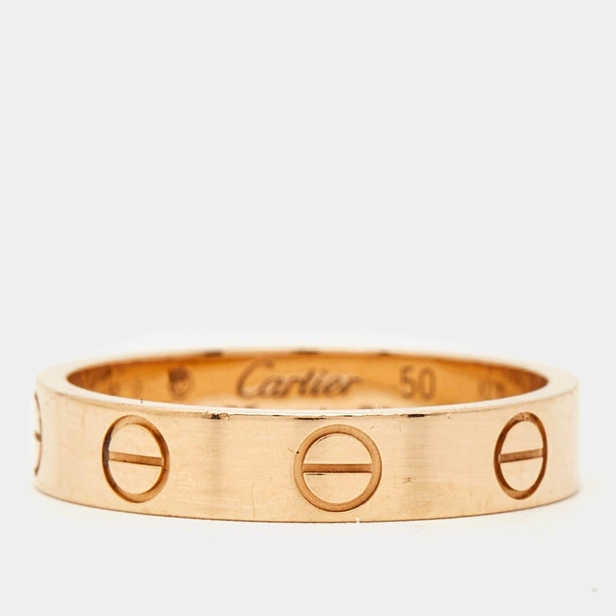 The Cartier Love wedding band ring embodies timeless romance with its sleek iconic design. Crafted from luxurious 18k rose gold this ring features signature screw motifs that symbolize everlasting love and commitment. Perfect for sealing your bond