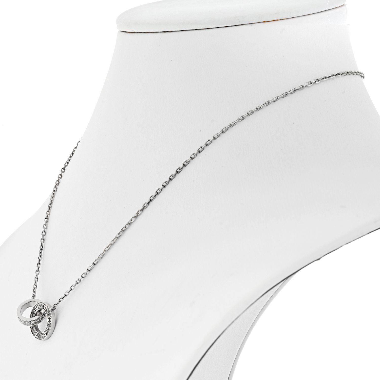 Cartier Love 18K White Gold Love Diamond Pave Pendant Necklace.
Celebrate timeless love with this necklace from Cartier's LOVE collection. It is made from 18K white gold and the chain holds two interlocking rings pendant decorated with the iconic