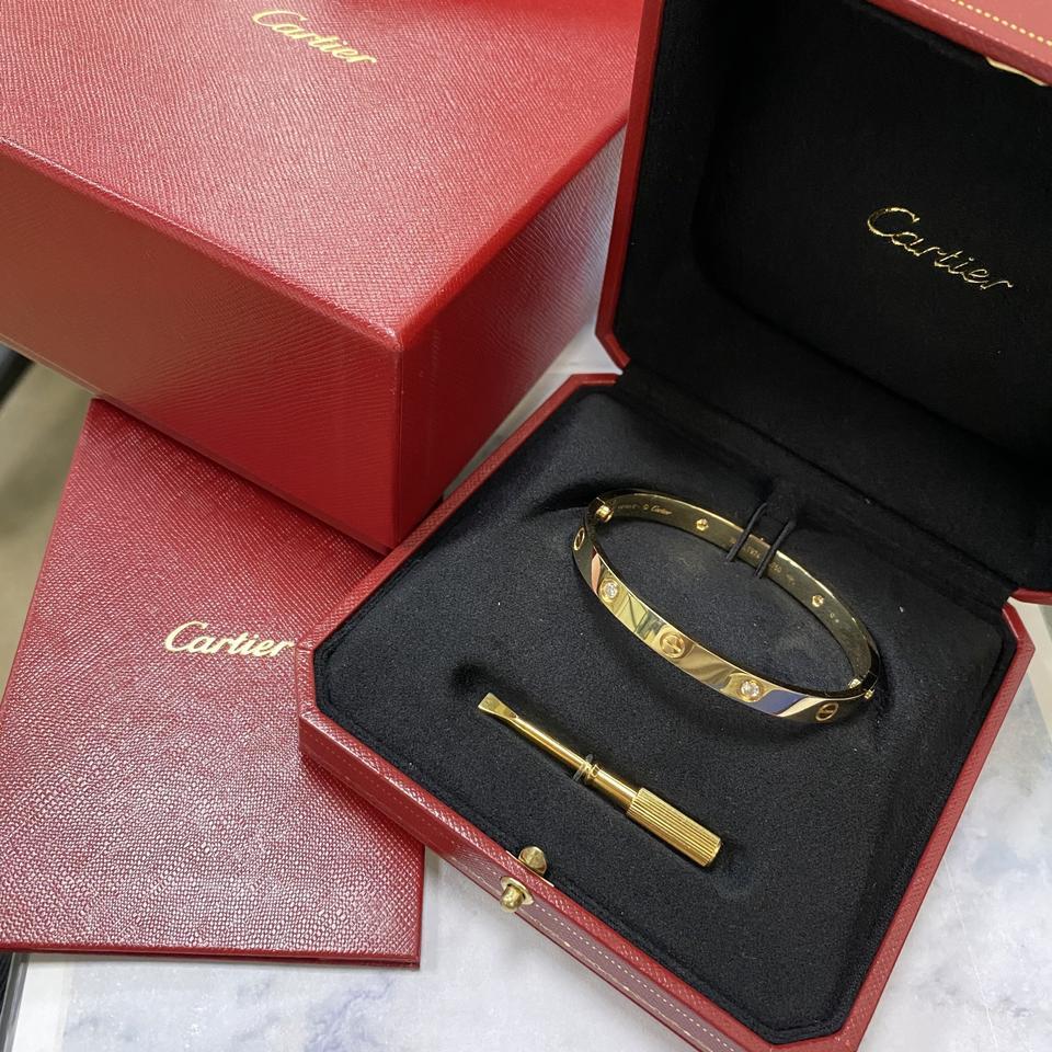 The famous Cartier Love bracelet, 18K yellow gold, set with 4 brilliant-cut diamonds totaling 0.42 carats. Size 18. Width: 6.1mm. Unworn condition. No signs of wear. Comes with original box, papers and a screwdriver. 