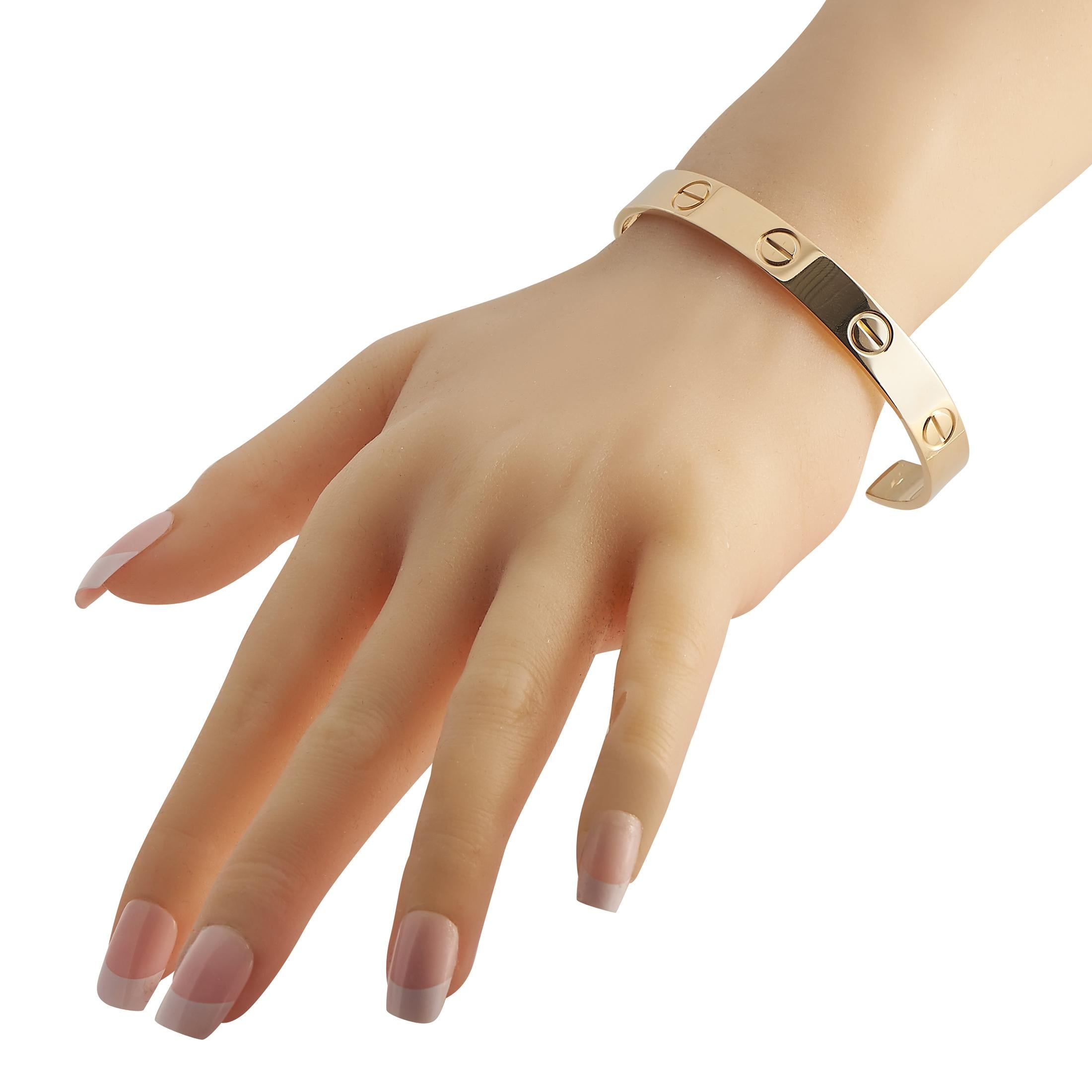 This Cartier LOVE cuff bracelet will add a touch of luxury to any ensemble. Made from opulent 18K Yellow Gold, it features the brands iconic motifs engraved around the perimeter of the design. This Size 20 bracelet measures 7.9 long.This jewelry