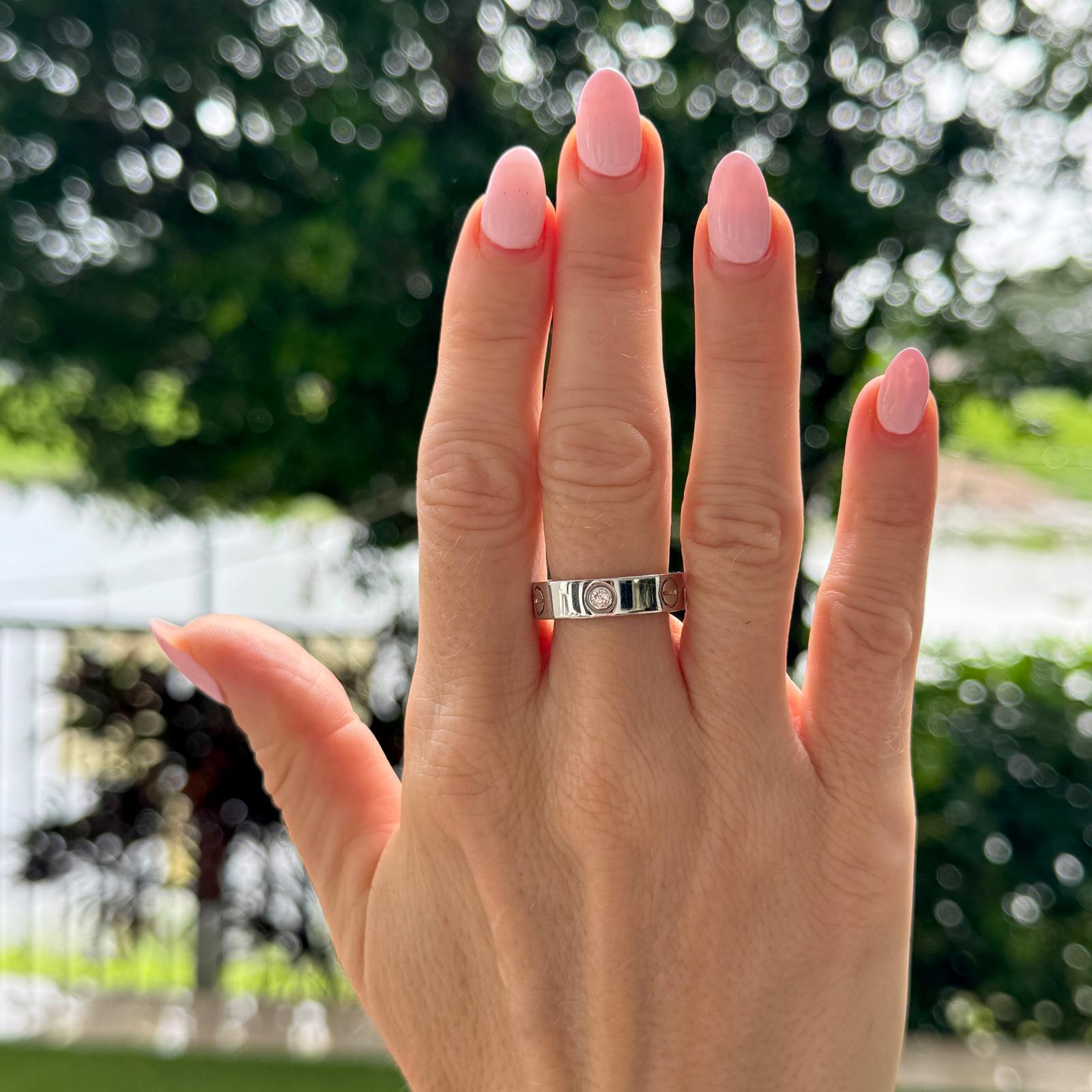 Questo classico anello Cartier LOVE in oro bianco 18 carati è caratterizzato da tre diamanti brillanti delicatamente incastonati nella fascia, che offrono uno scintillio sobrio e un'eleganza senza tempo. Questo anello, che fa parte dell'iconica