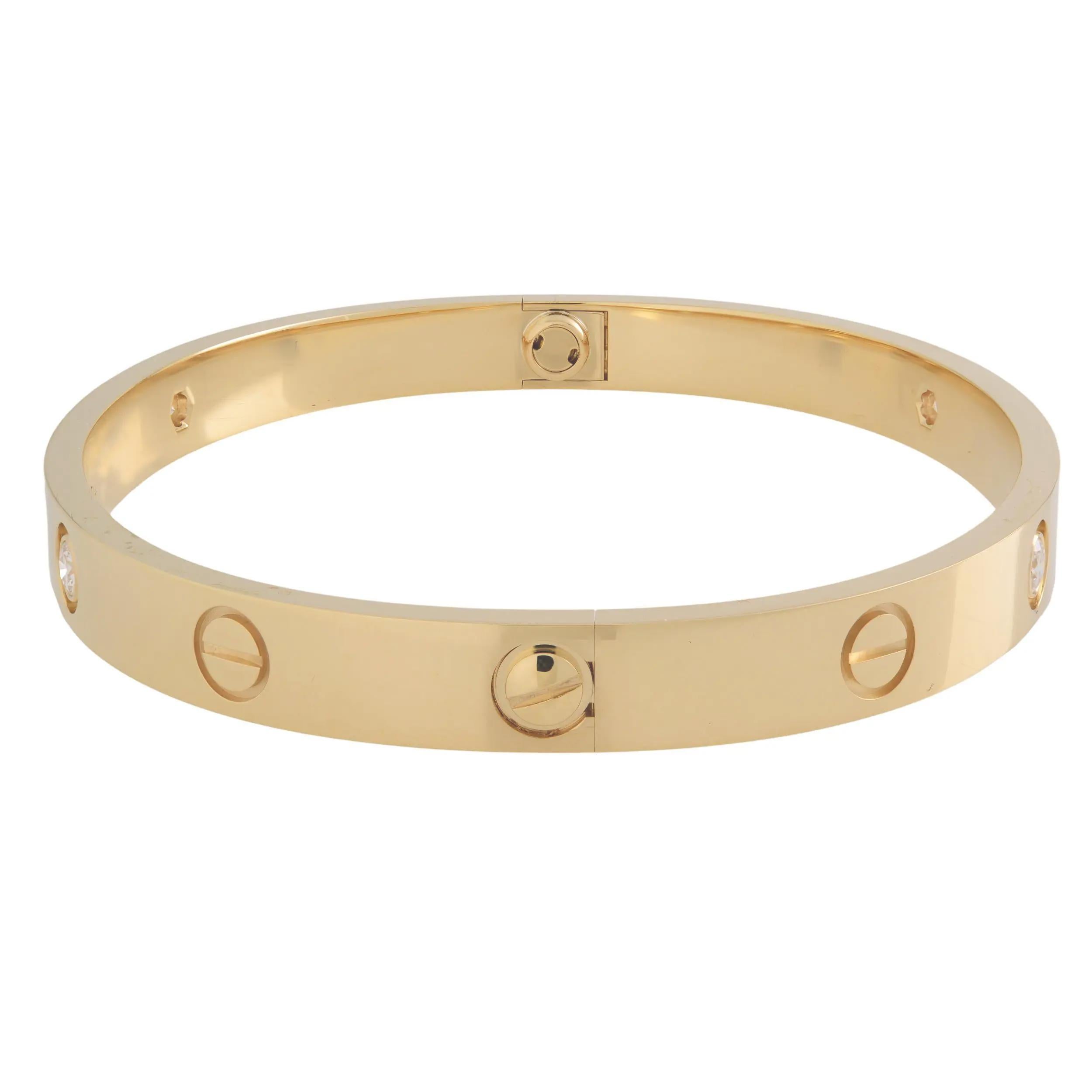 Cartier LOVE bracelet crafted in 18K yellow gold, set with 4 round brilliant cut diamonds weighing 0.42 carats. A close fitting, oval bracelet composed of two rigid arcs which are worn on the wrist and removed using a specific screwdriver. New style