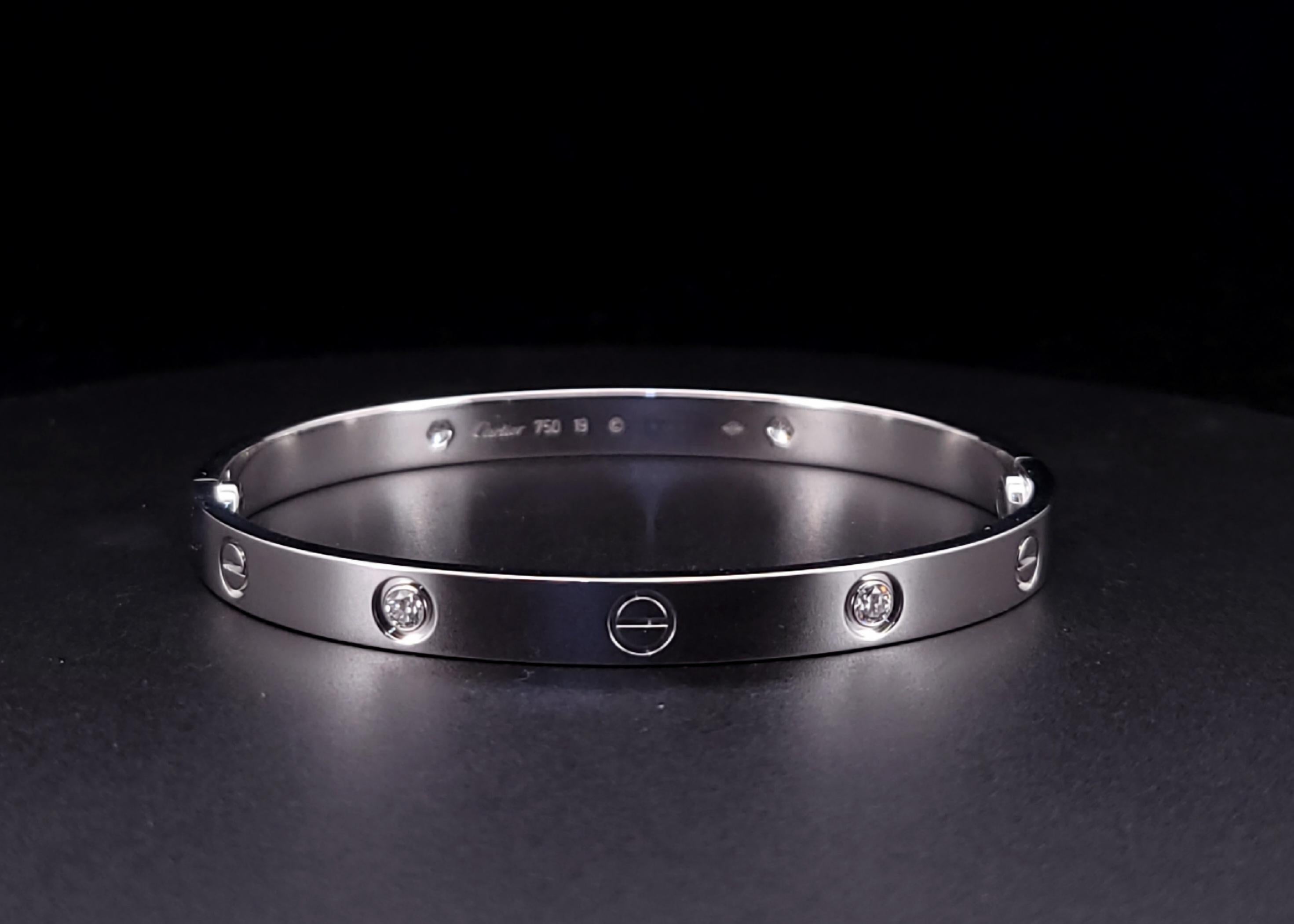 Armband LOVE, klassisches Modell, 18 Kt. Weißgold (750/1000), besetzt mit 4 Diamanten im Brillantschliff von insgesamt 0,42 Karat, Verschlusssystem mit Funktionsschraube und Scharnier. Wird mit einem Schraubendreher geliefert. Breite 6,1 mm.
 
Das