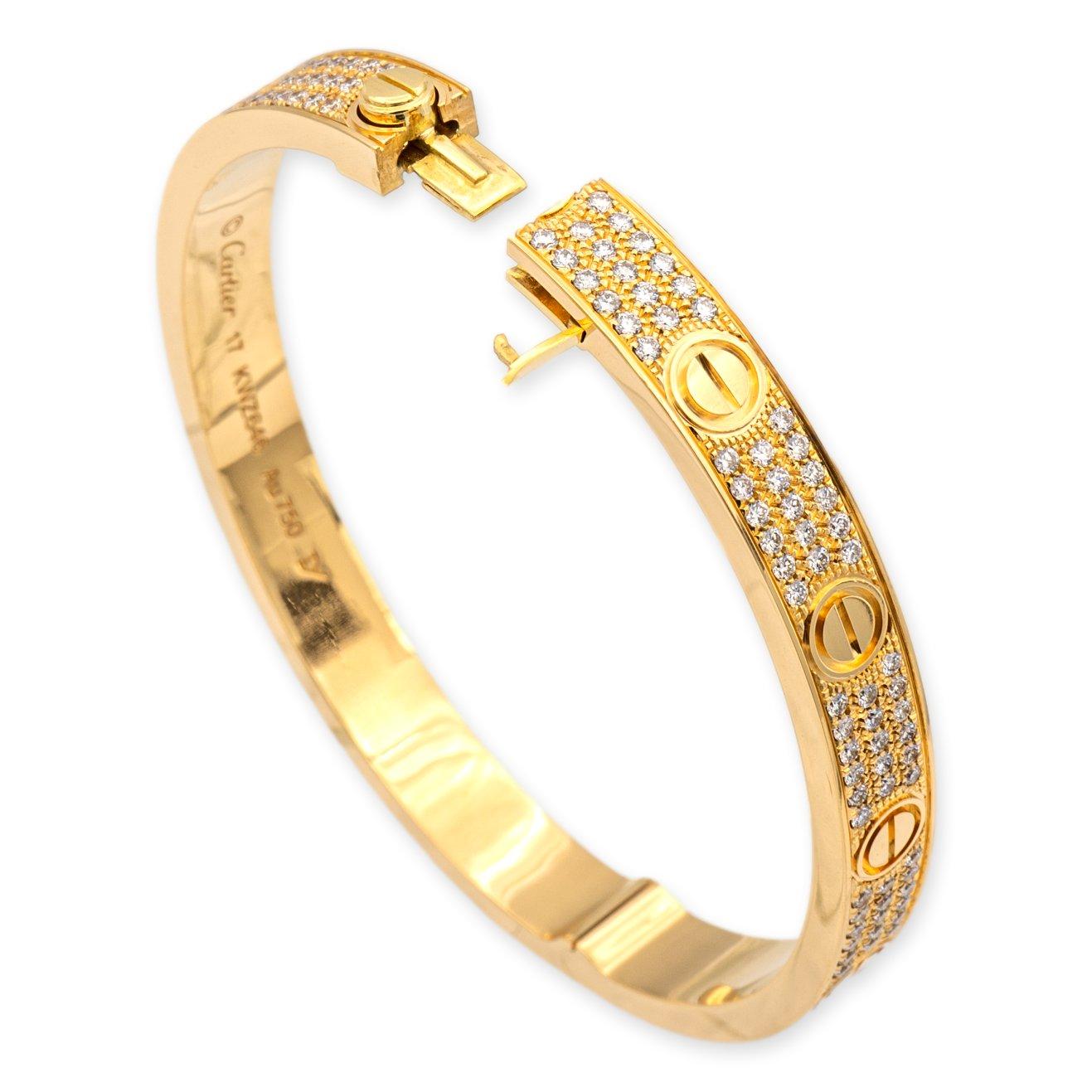 Cartier bangle bracelet from the iconic Love collection finely crafted in 18 karat yellow gold featuring 3 rows of pave set round brilliant cut diamonds weighing 2 carats total weight and screw motifs all the way around in a size 17.  Bracelet Has