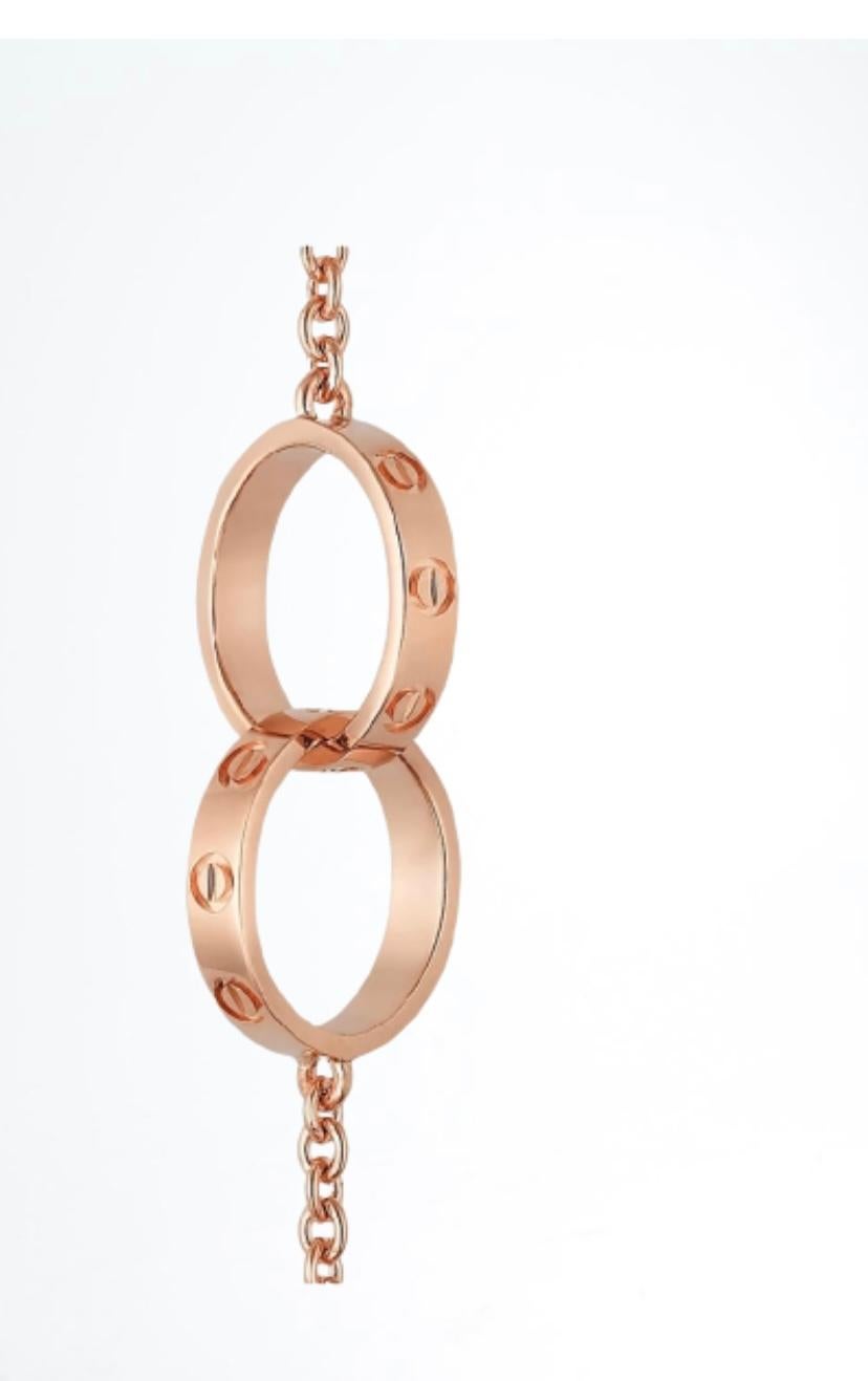Cartier Love Bracelet, 18 Carat Rose Gold with Two Interlocking Love Rings
Made of 18-carat rose gold, it features a chain that holds two beautiful interlocking rings. On both, one can see the iconic motifs of the screw which are a signature of the