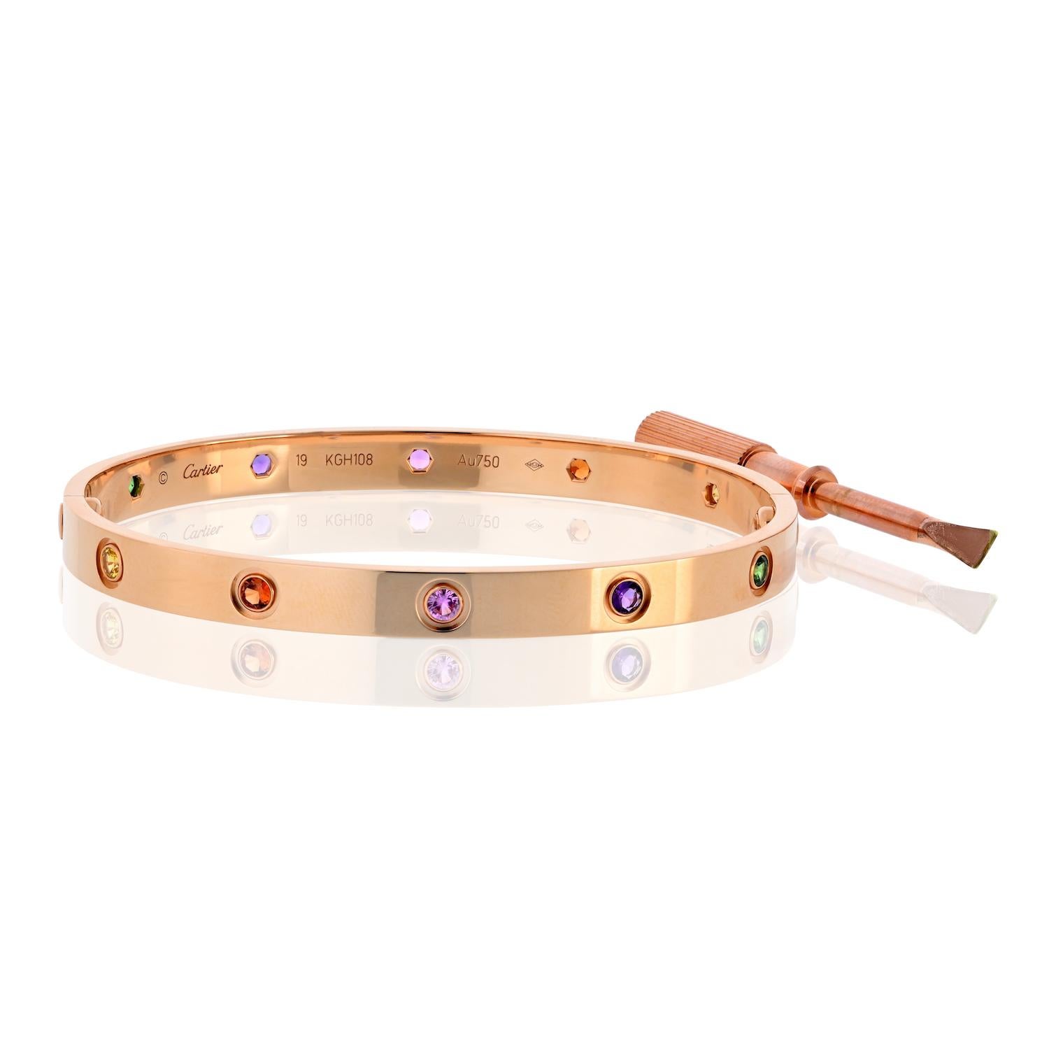 Este auténtico brazalete Cartier Love de segunda mano está elaborado en oro rosa de 18 quilates y engastado con un conjunto de vibrantes zafiros multicolores, creando un giro llamativo y alegre del diseño más icónico de Cartier. Esta rara variante