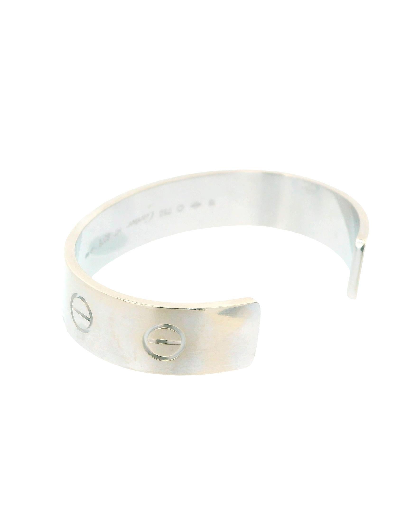 Le bracelet manchette LOVE de Cartier est un bijou luxueux qui illustre l'élégance intemporelle et le symbolisme romantique. Réalisée en or blanc 18 carats, elle présente les motifs à vis emblématiques de la marque, qui ajoutent une touche