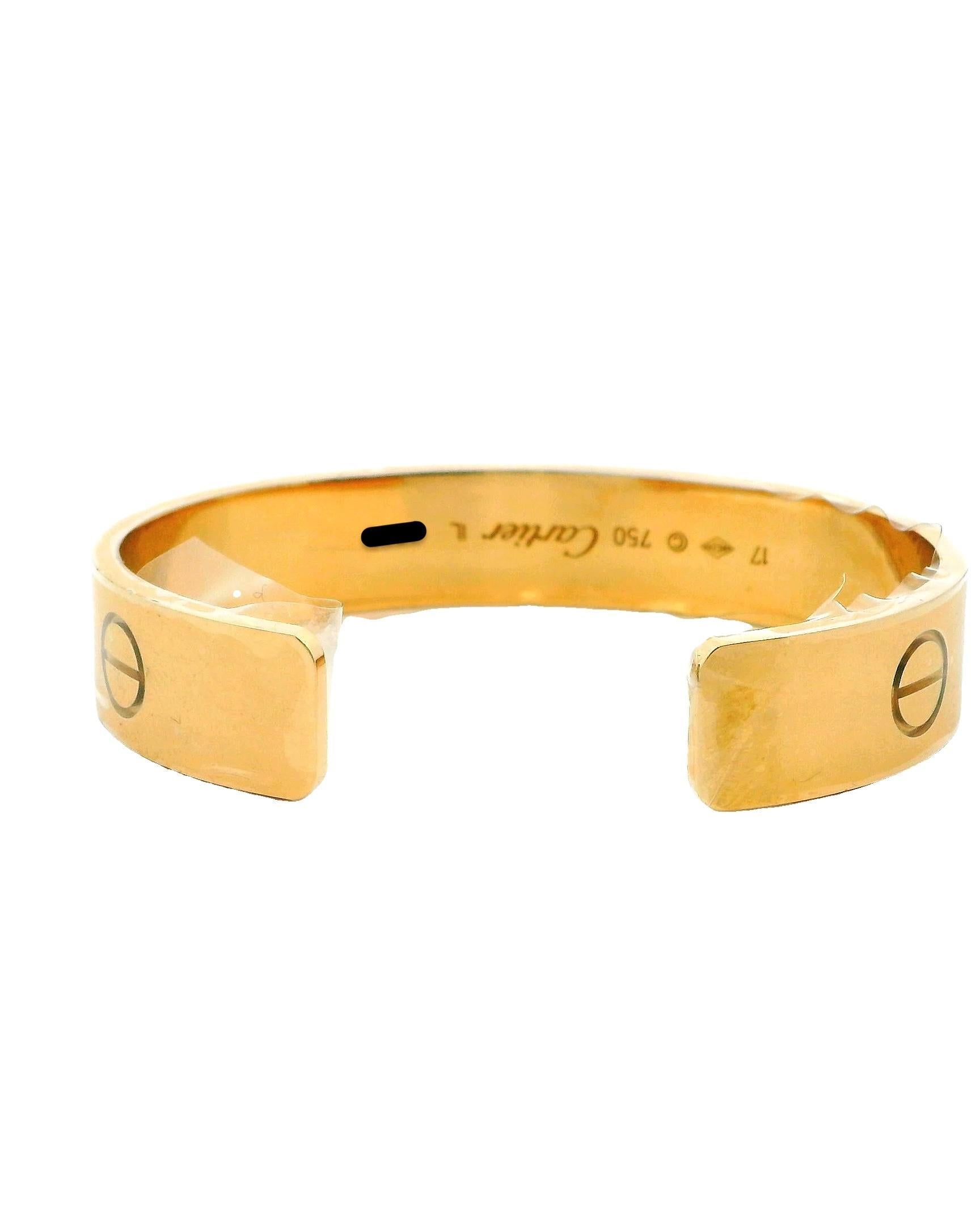 El brazalete puño LOVE de Cartier es una lujosa pieza de joyería que ejemplifica la elegancia atemporal y el simbolismo romántico. Fabricado en oro amarillo de 18 quilates, incorpora los característicos motivos de tornillo de la marca, que añaden un