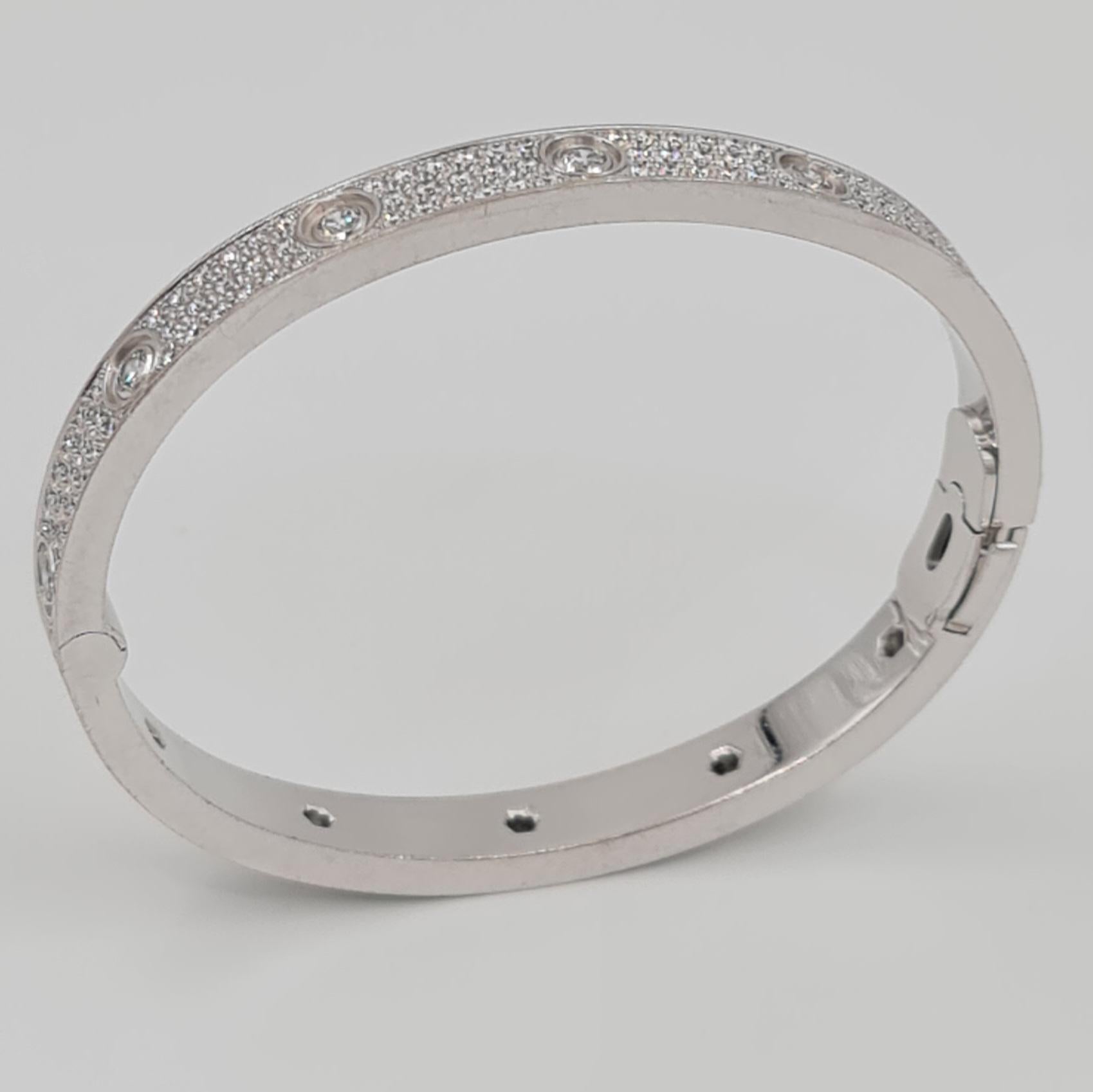 Authentic Cartier 'Love' bangle bracelet crafted in 18 carat white gold with diamond screw tops and pave set round brilliant cut diamonds (D-F in color, VVS clarity) for an estimated 3.70 carats total weight. Size 17. Signed Cartier, 17, 750, with