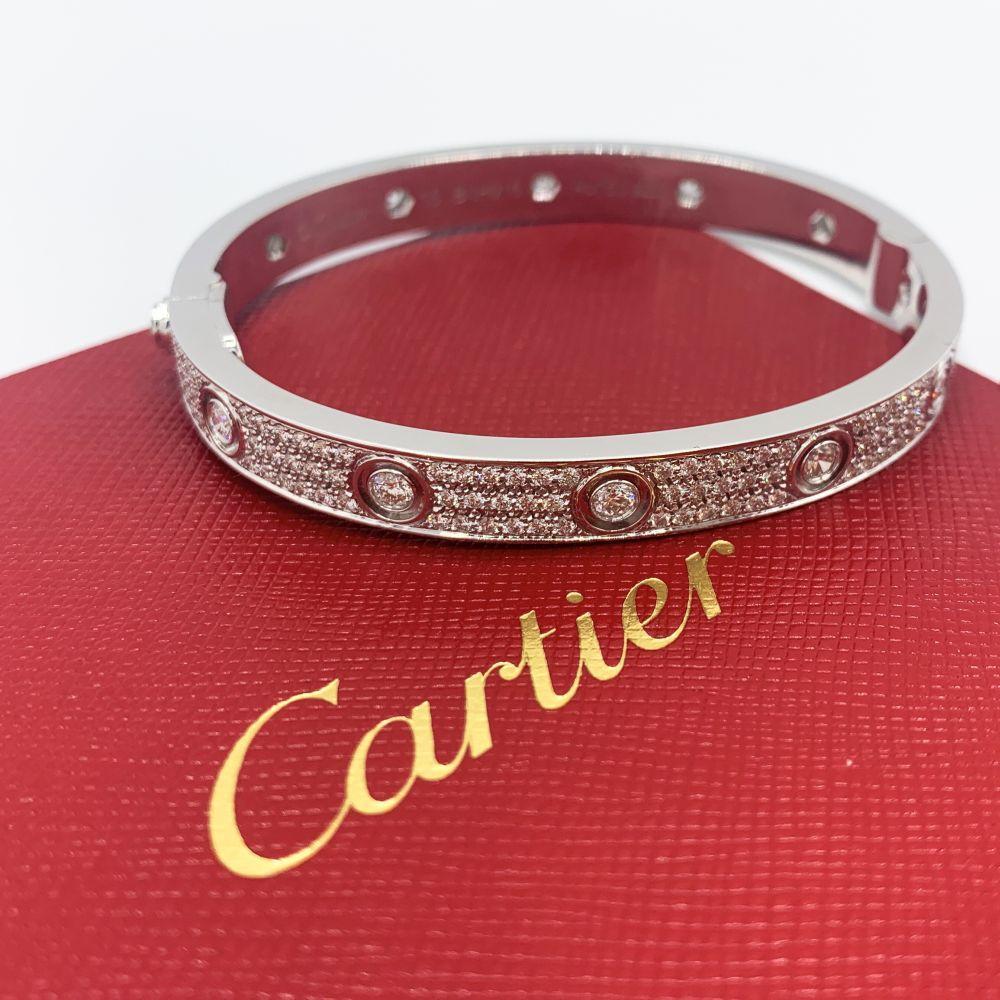 CARTIER LOVE BRACELET
Cartier 'Love' bangle bracelet crafted in 18 karat white gold with diamond screw tops and pave set round brilliant cut diamonds (D-F in color, VVS clarity)
Signed Cartier, 17, 750, with serial number and hallmarks 
The bracelet