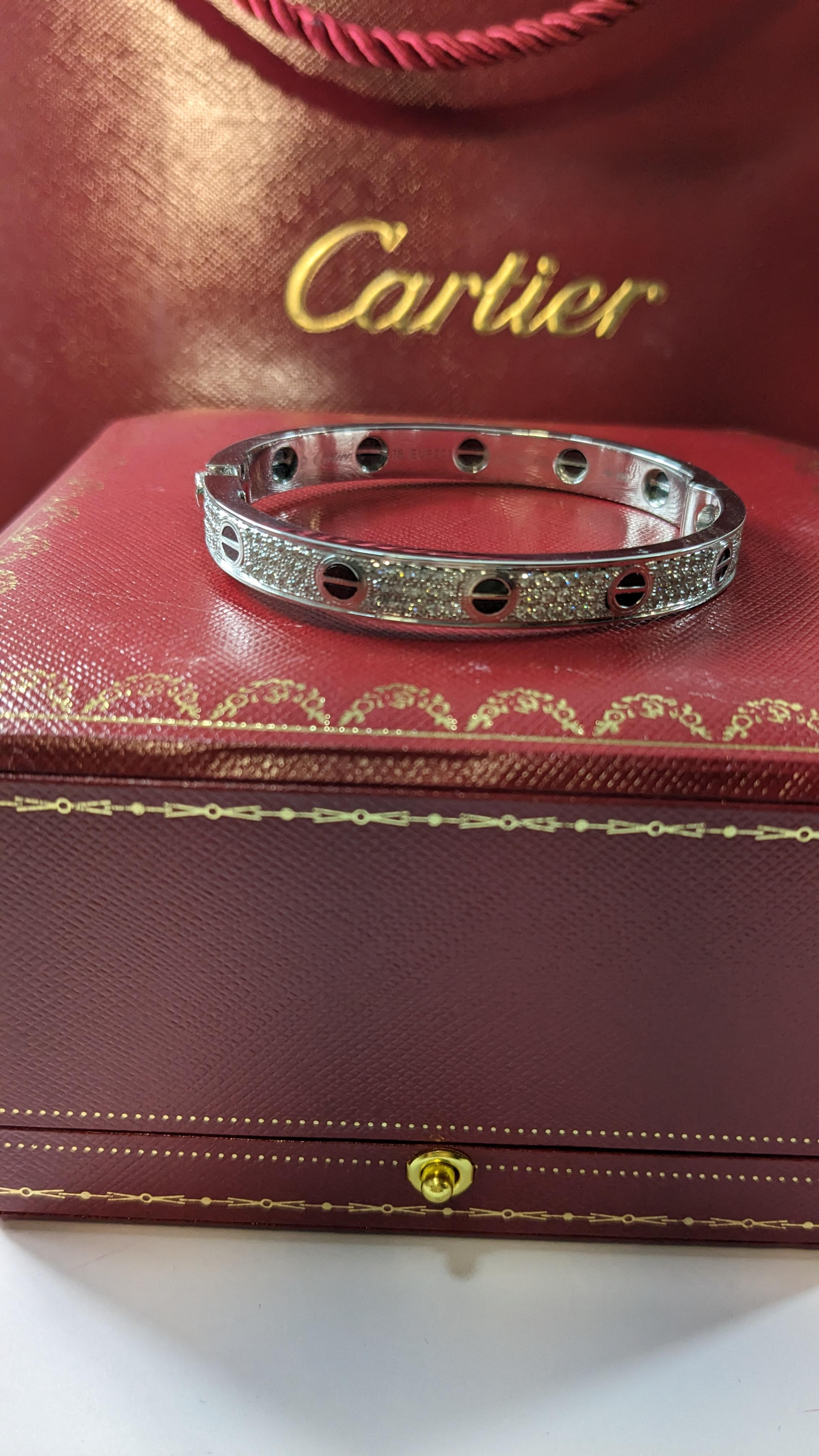 CARTIER LOVE BRACELET size 18
Cartier 'Love' bangle bracelet crafted in 18 karat white gold with diamond screw tops and pave set round brilliant cut diamonds (D-F in color, VVS clarity), ceramique noir
Signed Cartier 750, with serial number and