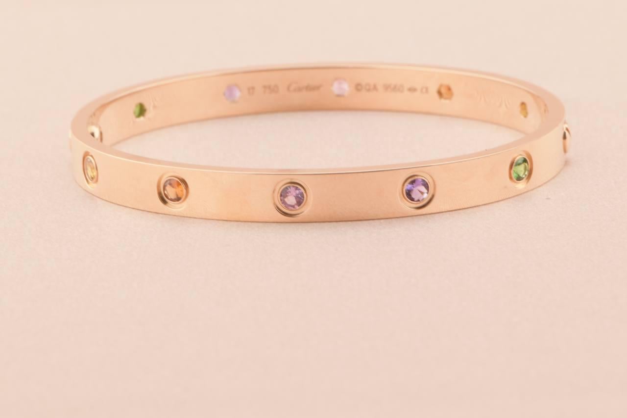 LOVE bracelet, 18K rose gold, set with 2 pink sapphires, 2 yellow sapphires, 2 green garnets, 2 orange garnets, and 2 amethysts. 
_____________________________________________________________
Dandelion Antiques Code AT-0980
Brand Cartier
Model