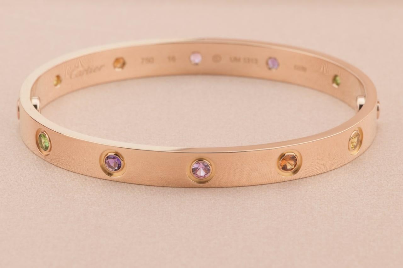 LOVE bracelet, 18K rose gold, set with 2 pink sapphires, 2 yellow sapphires, 2 green garnets, 2 orange garnets, and 2 amethysts. 
____________________________________

Dandelion Antiques Code:  AT-0949
Brand:  Cartier
Model:  B6036518
Date: 