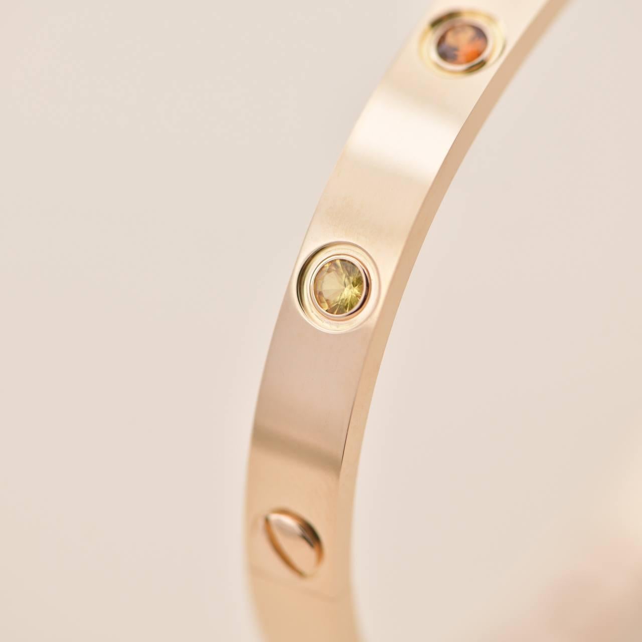 LOVE bracelet, 18K rose gold, set with 2 pink sapphires, 2 yellow sapphires, 2 green garnets, 2 orange garnets, and 2 amethysts. 
_____________________________________________________________
SKU AT-1543
Brand Cartier
Model B6036517
Date Approx.