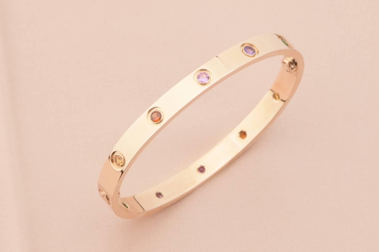 LOVE bracelet, 18K rose gold, set with 2 pink sapphires, 2 yellow sapphires, 2 green garnets, 2 orange garnets, and 2 amethysts. 
_____________________________________________________________
Dandelion Antiques Code AT-1180
Brand Cartier
Model