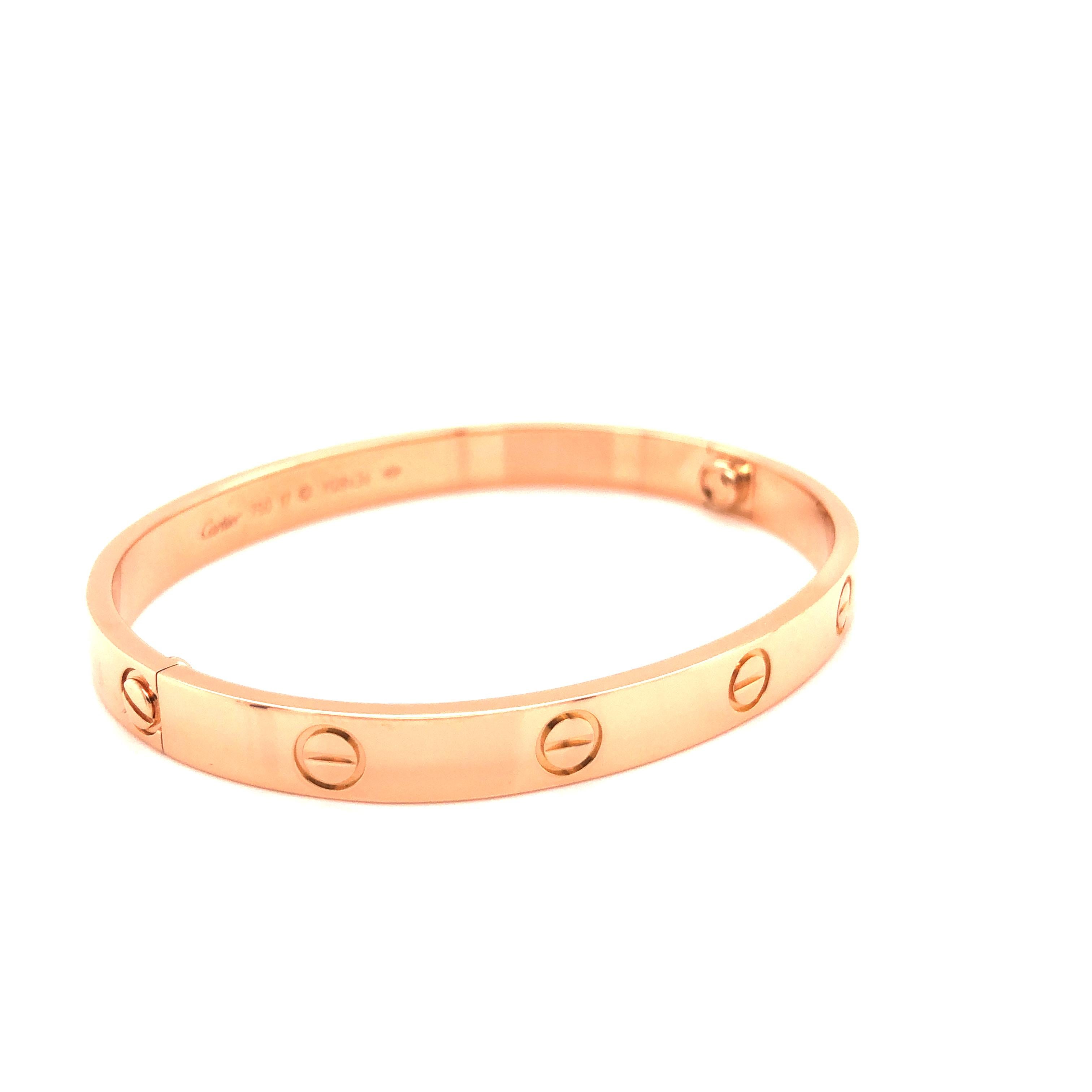 A signature 18k Rose Gold Cartier bracelet from the Love collection. The bracelet is a size 17. Original box and key included as well as Cartier paperwork. Pristine condition, shows no scratches or wear. New screw system. All Photos taken under 20x
