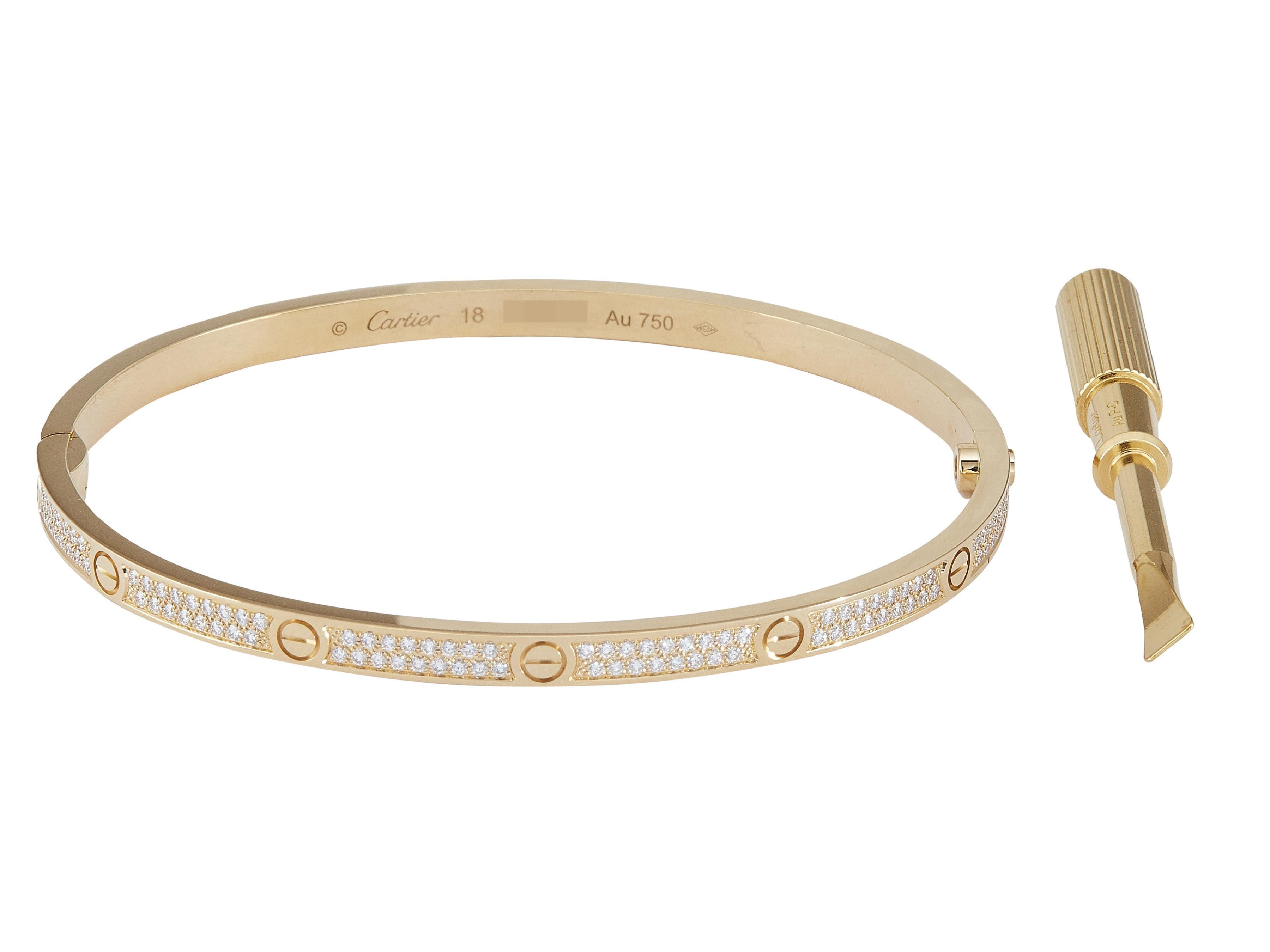 Der Armreif: Ein Cartier LOVE-Armband mit einem Verschluss mit einer einzigen Schraube. Dieses kleine Modell ist aus achtzehn Karat Gelbgold gefertigt und mit runden Diamanten im Brillantschliff besetzt. Es ist eine Größe 18.

Begleitet von