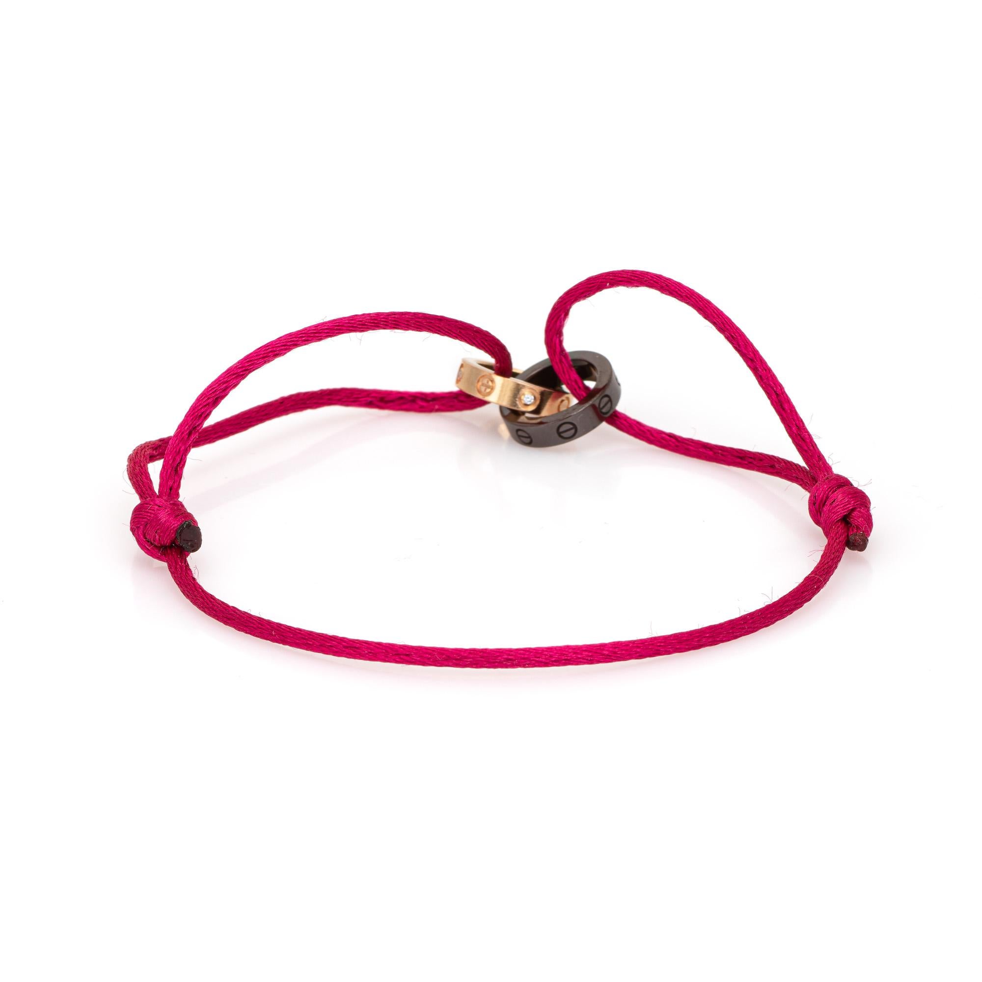 Estate Cartier LOVE charity bracelet crafted in 18 karat white gold.  

The out of production bracelet is a Cartier classic. Originally released in 2006, the Love Charity bracelet is fitted with a pink silk cord and 18k gold 4 diamond & ceramic