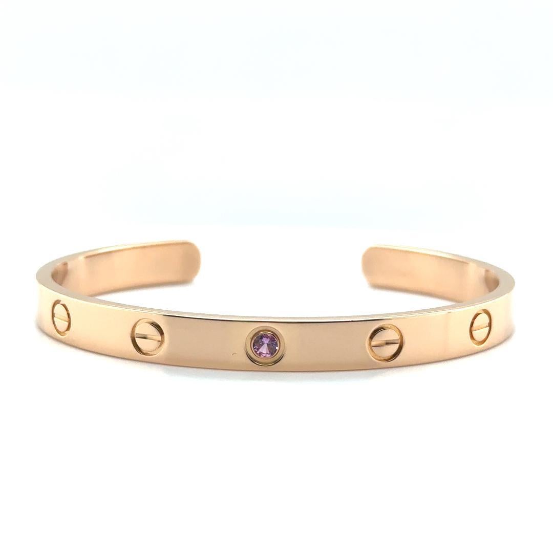 Elegant design by renowned jewelry house Cartier. This exquisite cuff bracelet is a signature piece.

This bracelet is crafted in luxurious 18k rose gold, featuring a sleek and polished finish. Adorning the bracelet is a single round-cut pink