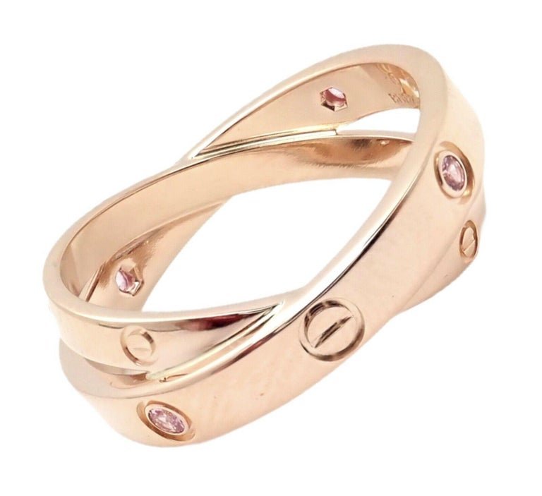 18k Rose Gold Diamond Pink Sapphire LOVE Band Ring by Cartier. 
With 2 round brilliant cut diamonds VS1 clarity, G color total weight .04ct
4 round pink sapphries approx 2mm each
Details: 
Band Width: 8mm
Weight: 7 grams
Ring Size: European 57, US