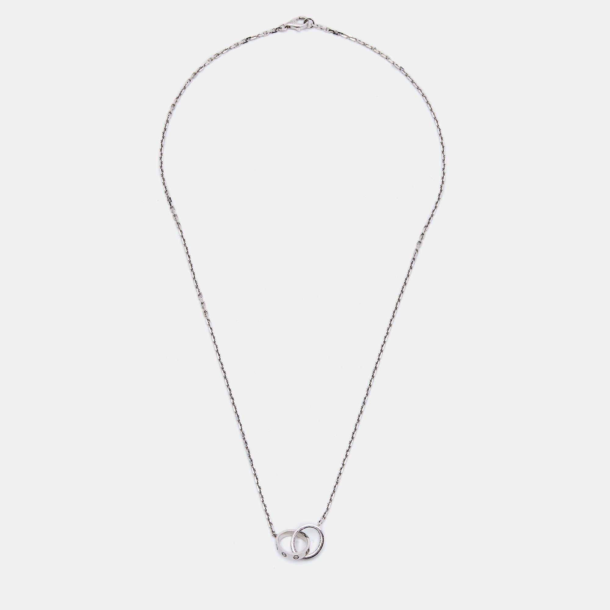 Le collier Love de Cartier est une pièce exquise réalisée en or blanc 18 carats. Il présente des anneaux entrelacés ornés de diamants taille brillant et de motifs à vis, dégageant une élégance et une sophistication intemporelles. Ce collier