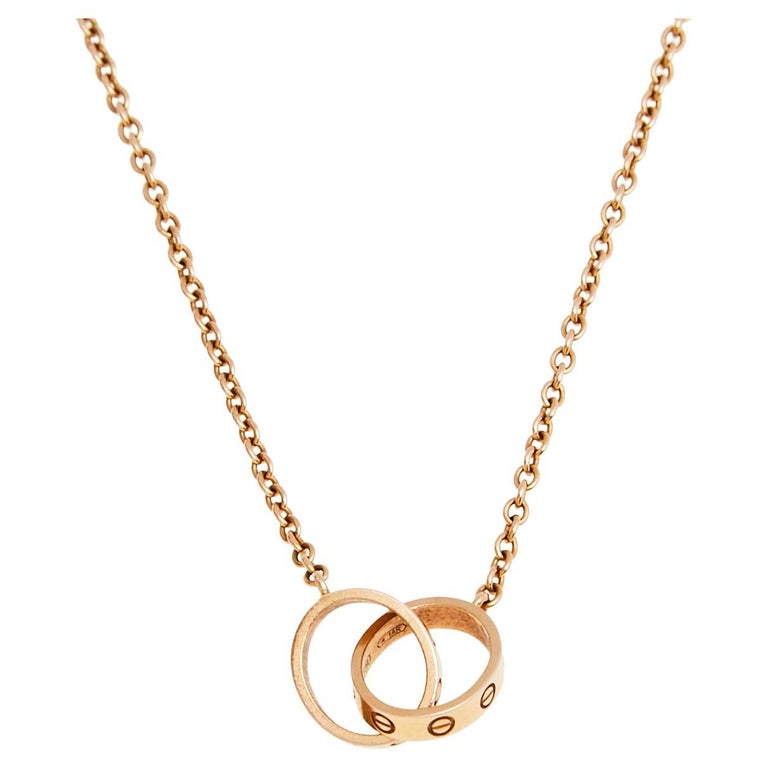 Cartier, collier en or rose 18 carats avec deux anneaux d'amour imbriqués  sur 1stDibs