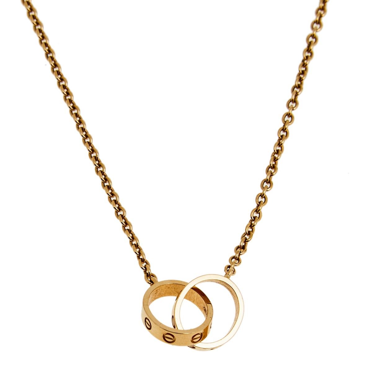 Celebrate timeless love with this necklace from Cartier's Love collection. It is sculpted from 18k rose gold, and the chain holds two magnificent hoops interlocked with one another. Both the rings carry the iconic screw motifs—a signature of the