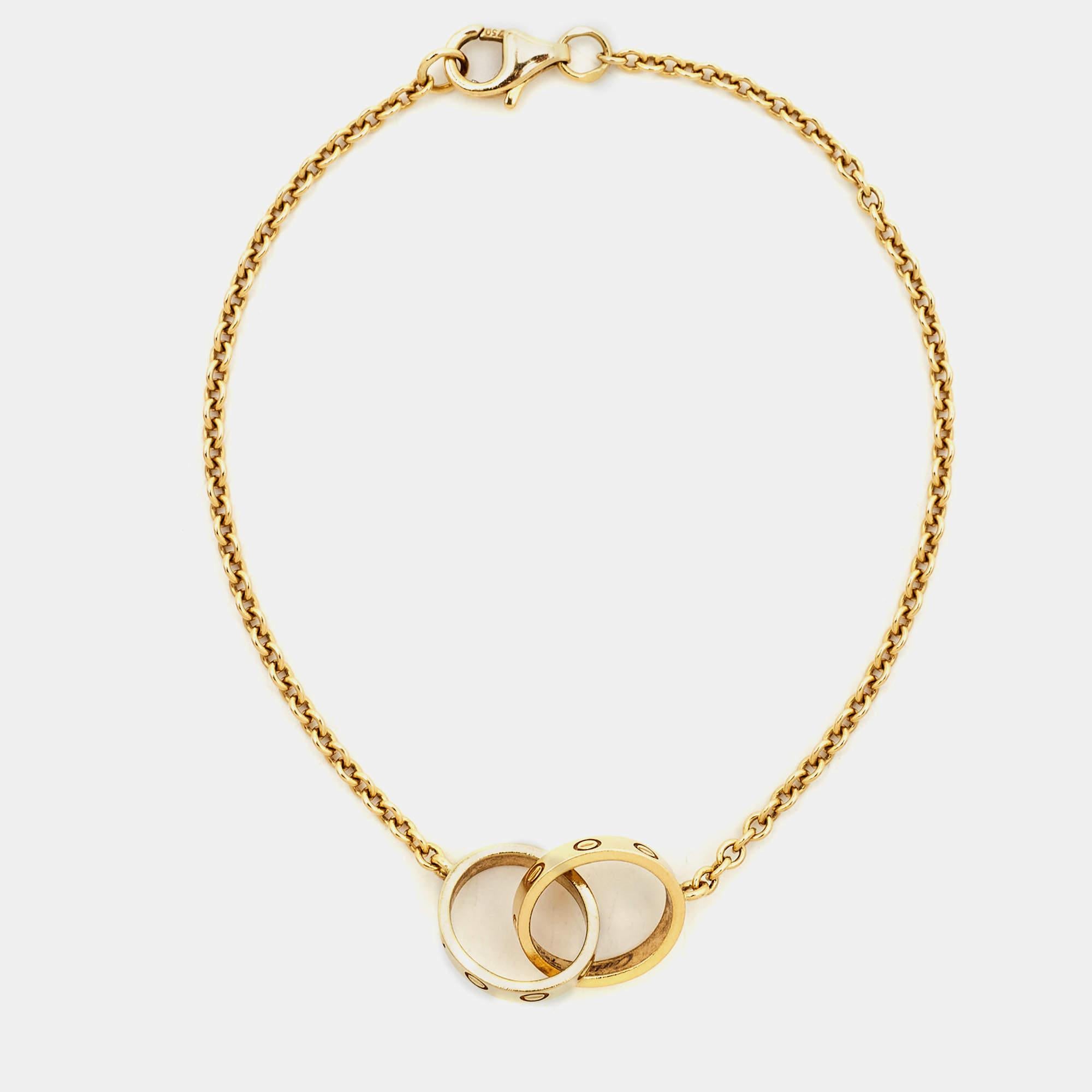 Celebrate timeless love with this bracelet from Cartier's Love collection. Made from 18k yellow gold, it has a chain that holds two magnificent rings interlocked with one another. On both, one can see the iconic screw motifs — a signature of the