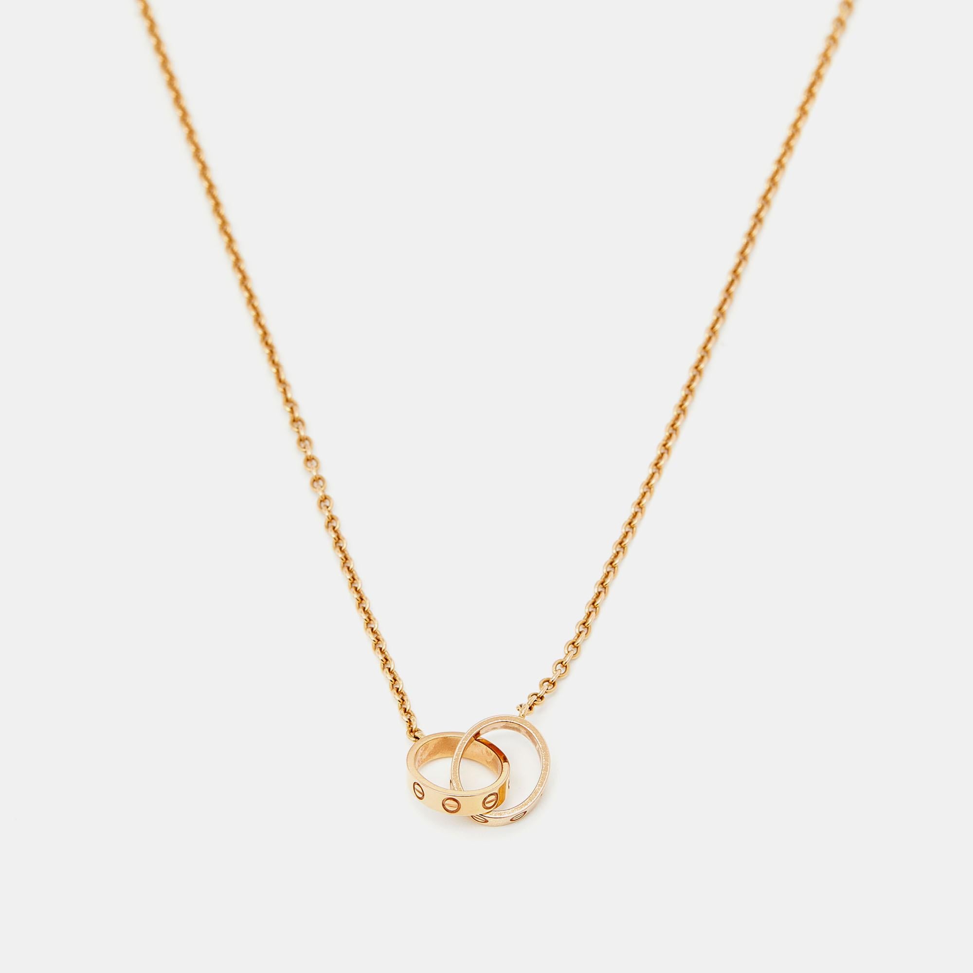 Celebrate timeless love with this necklace from Cartier's Love collection. It is sculpted from 18k rose gold, and the chain holds two magnificent hoops interlocked with one another. Both the rings carry the iconic screw motifs—a signature of the