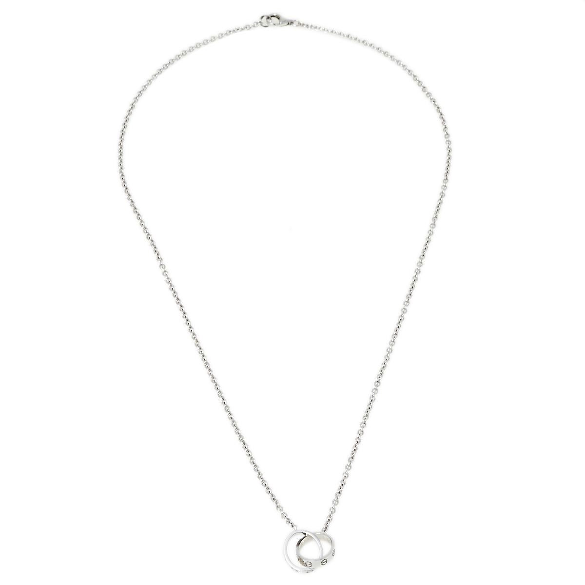 Celebrate timeless love with this necklace from Cartier's Love collection. It is made from 18k white gold and the chain holds two magnificent hoops interlocked with one another. Both the rings carry the iconic screw motifs which are a signature of