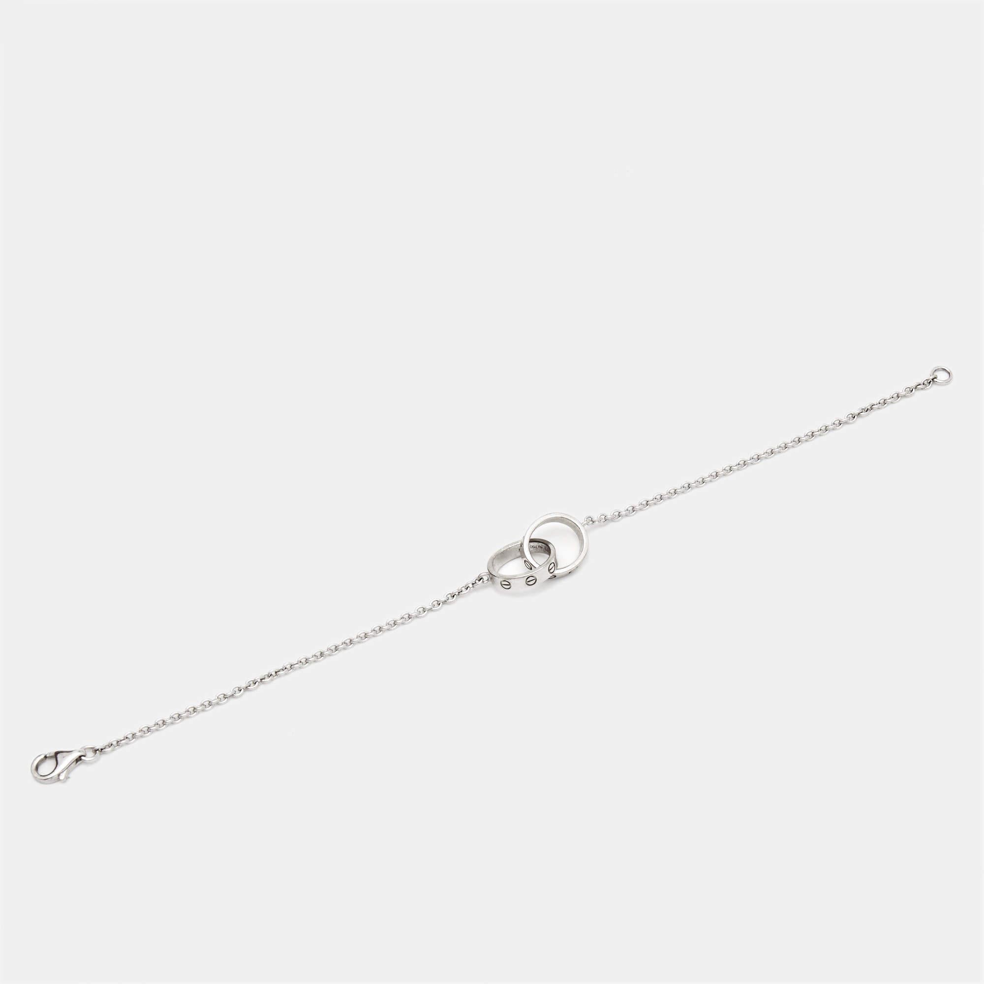Celebrate timeless love with this bracelet from Cartier's Love collection. It is sculpted from 18k white gold, and the chain holds two magnificent hoops interlocked with one another. Both the rings carry the iconic screw motifs—a signature of the