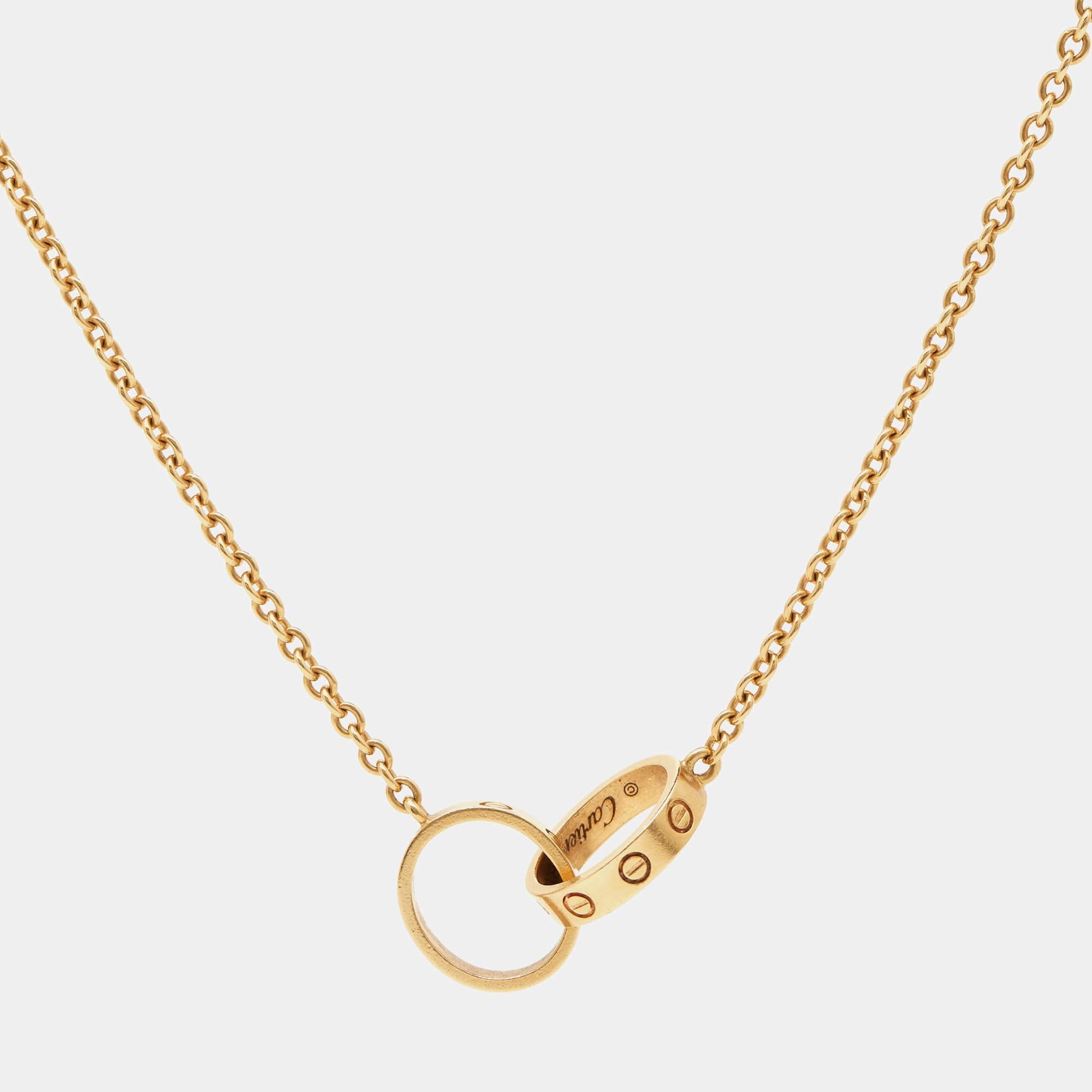 Celebrate timeless love with this necklace from Cartier's Love collection. It is made from 18k yellow gold, and the chain holds two magnificent loops interlocked with one another. Both the rings carry the iconic screw motifs, which are a signature