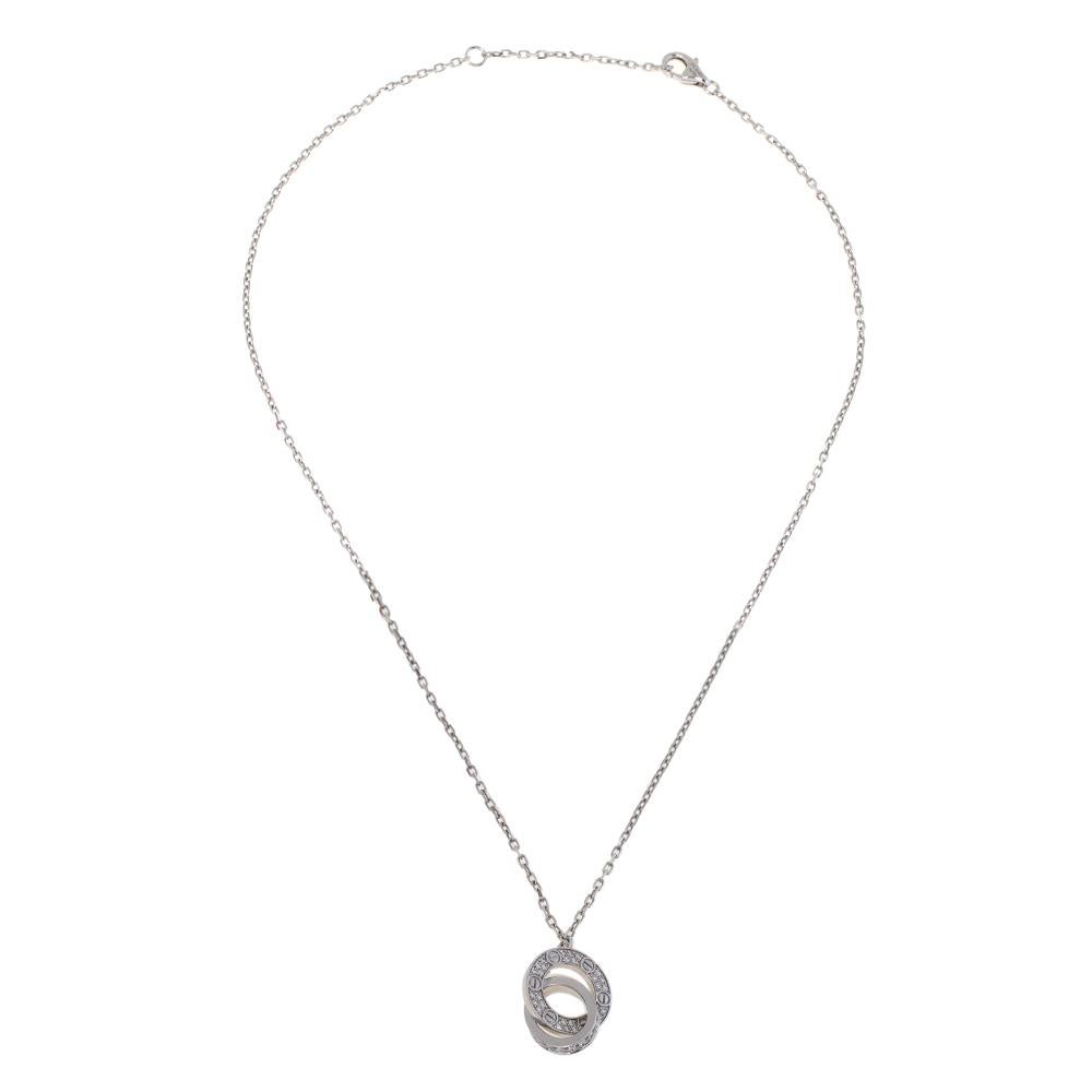 Celebrate timeless love with this necklace from Cartier's LOVE collection. It is made from 18K white gold and the chain holds two interlocking rings pendant decorated with the iconic screw motifs and pavé diamonds of approximately 0.30ct. This piece