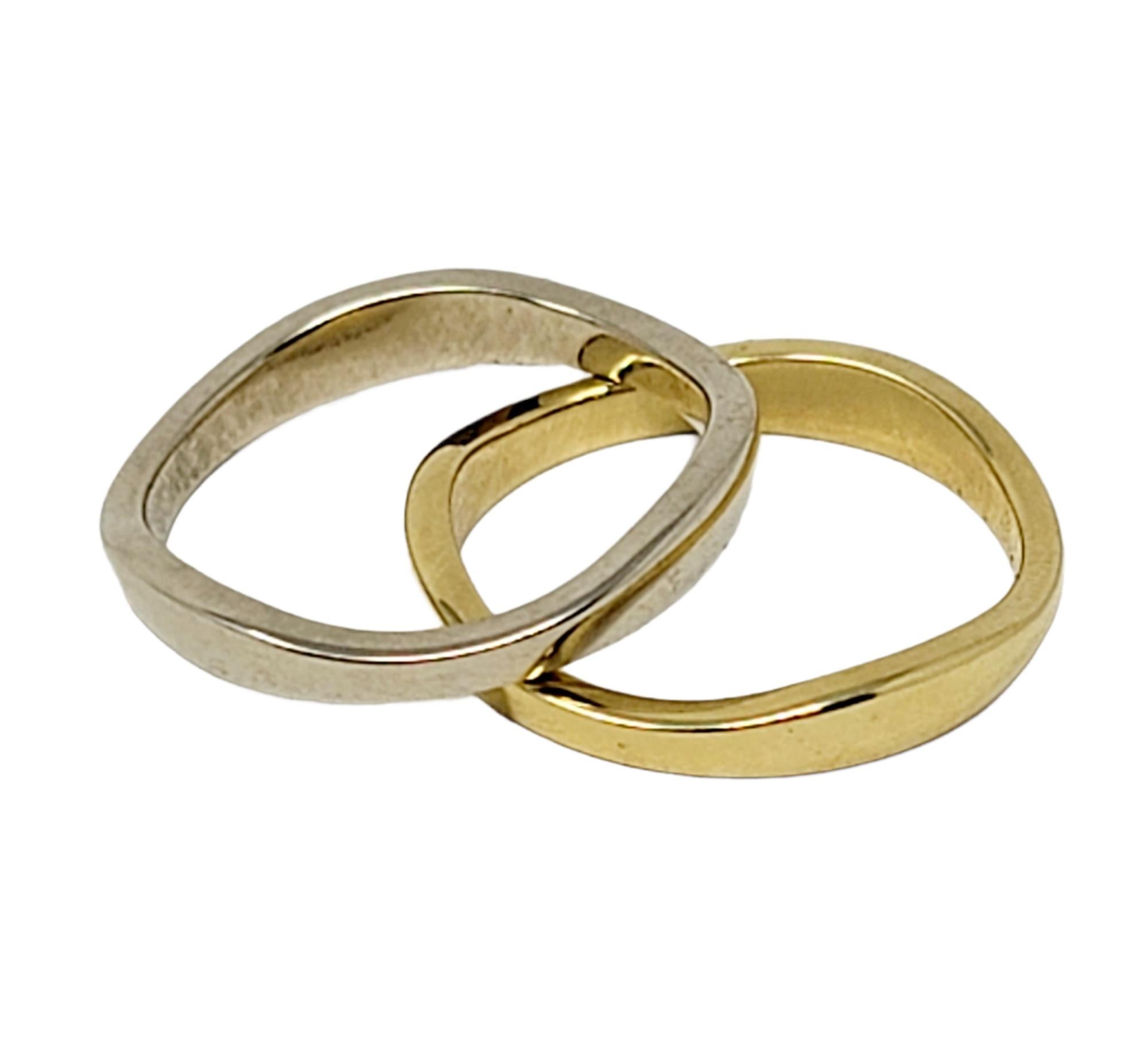 Timeless 'Love Me' multi band ring set by famed jeweler, Cartier. Featuring two individual bands with an undulating design that allows the two rings to fit together. It is the perfect gift for any loved one in your life! Each gold ring is slightly