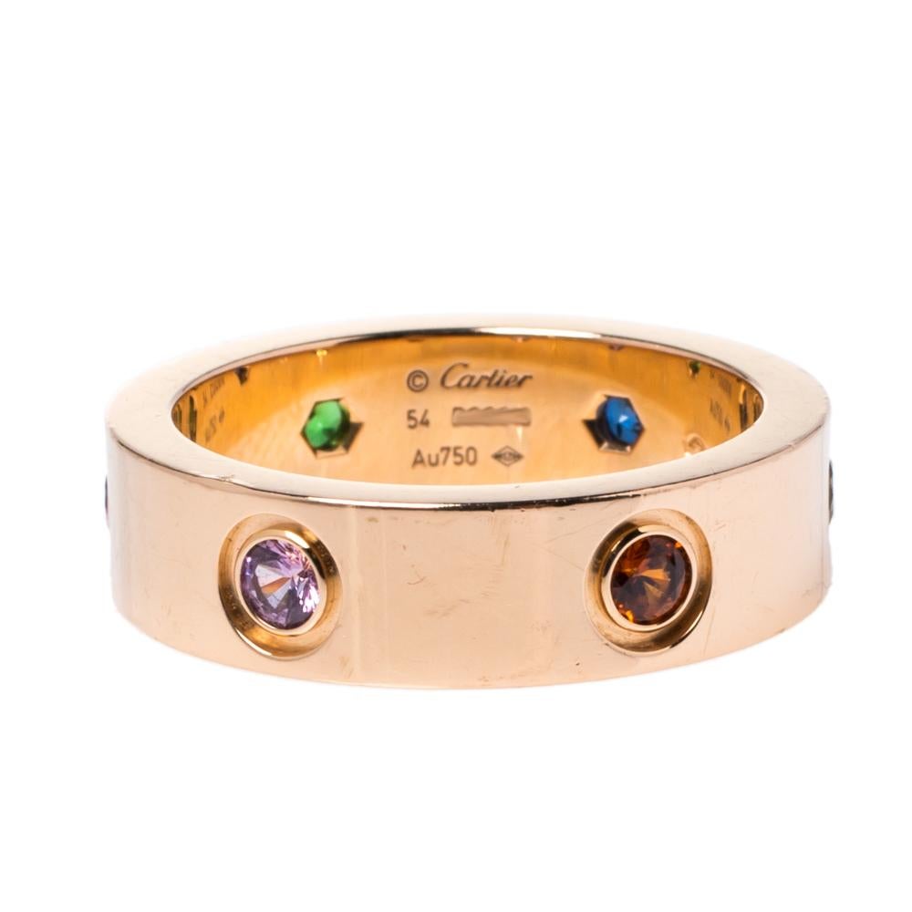 One of the most iconic and loved designs from the house of Cartier, this stunning LOVE ring is an icon of style and luxury. Constructed in 18k rose gold, this ring features colorful gemstones all around the surface in lieu of the characteristic