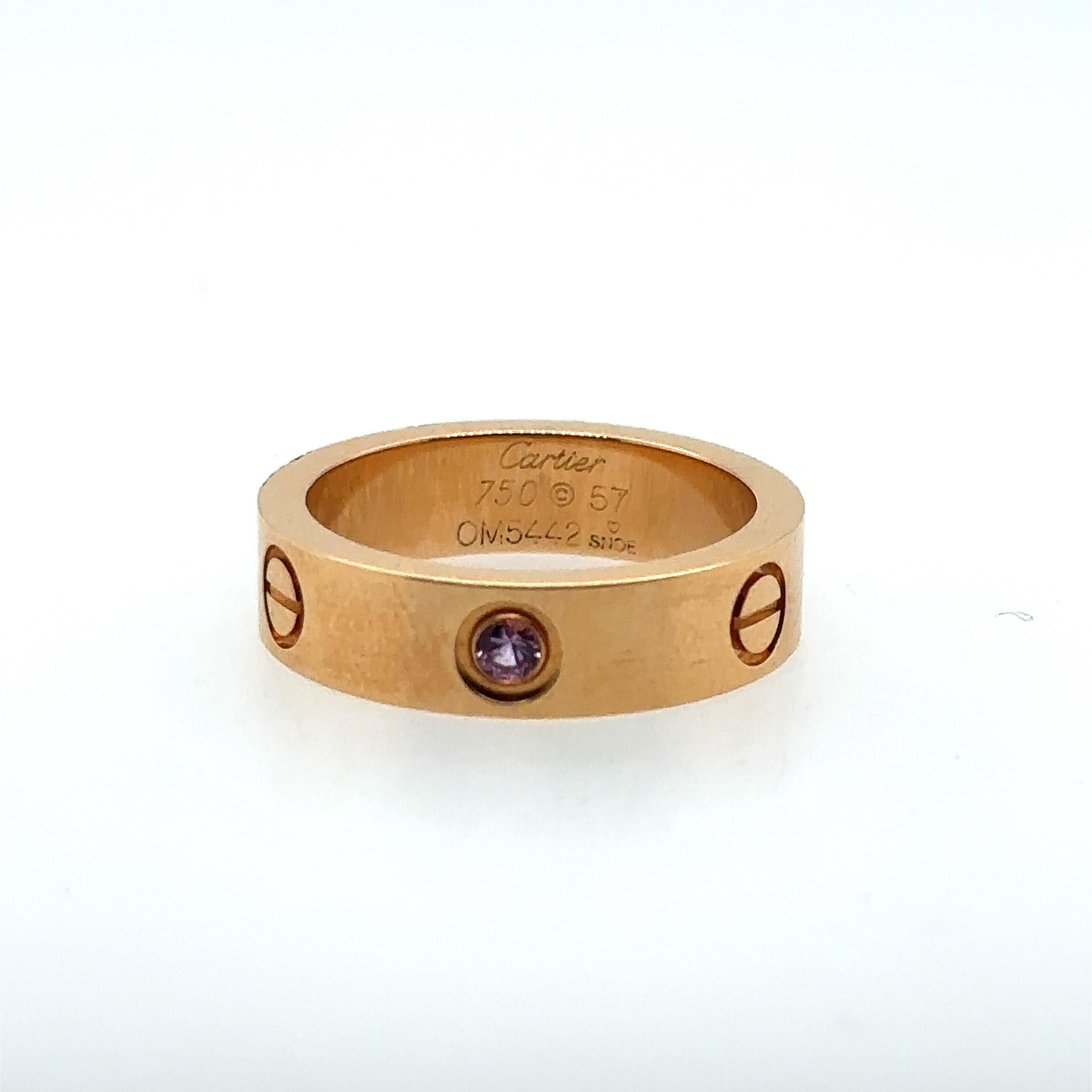 18k yellow gold Cartier LOVE ring set with a single pink sapphire. Size 8. Total weight: 10.5 grams. Comes with certificate of authenticity #GT5171 and dated April 7, 2009, also comes with original box.