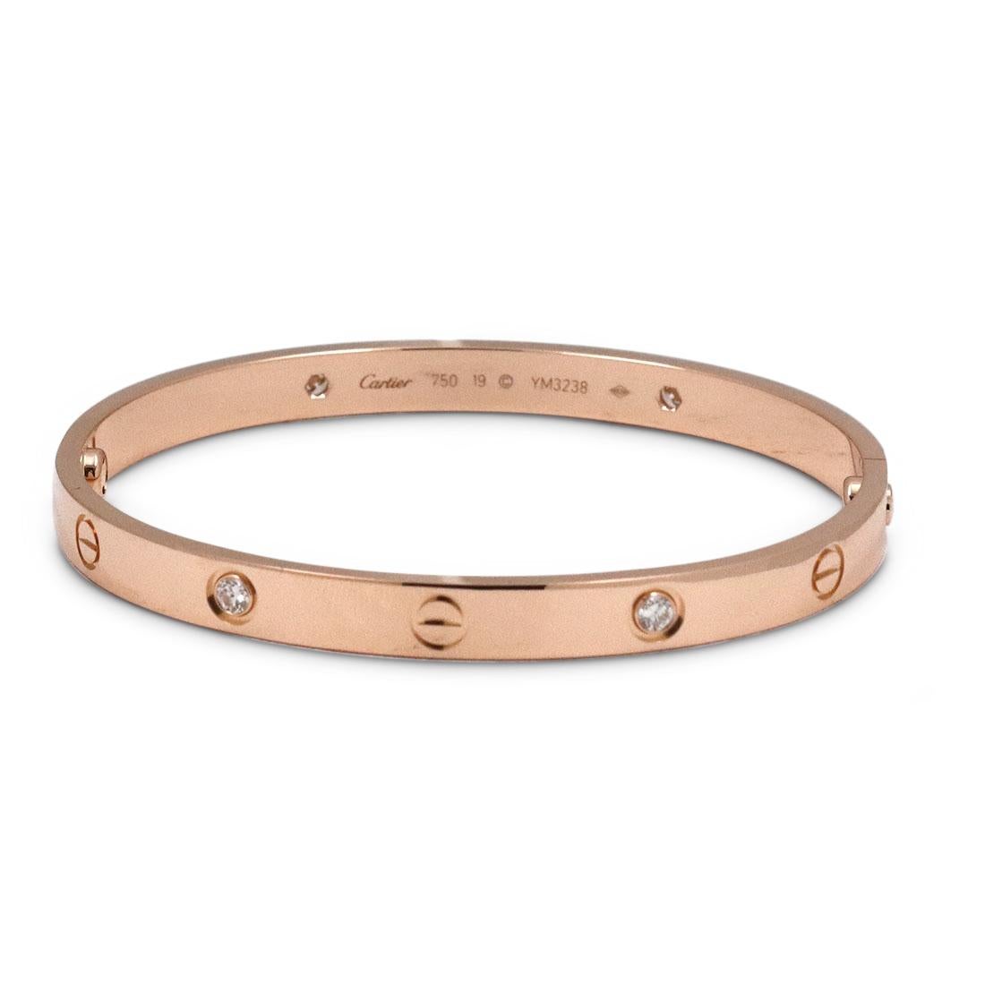 Authentic Cartier 'Love' bracelet crafted in 18 karat rose gold and set with four high-quality round brilliant cut diamonds (E-F color, VS clarity) weighing an estimated .42 carats total. Size 19 (US 6 1/2). Signed Cartier, 750, 19, with serial