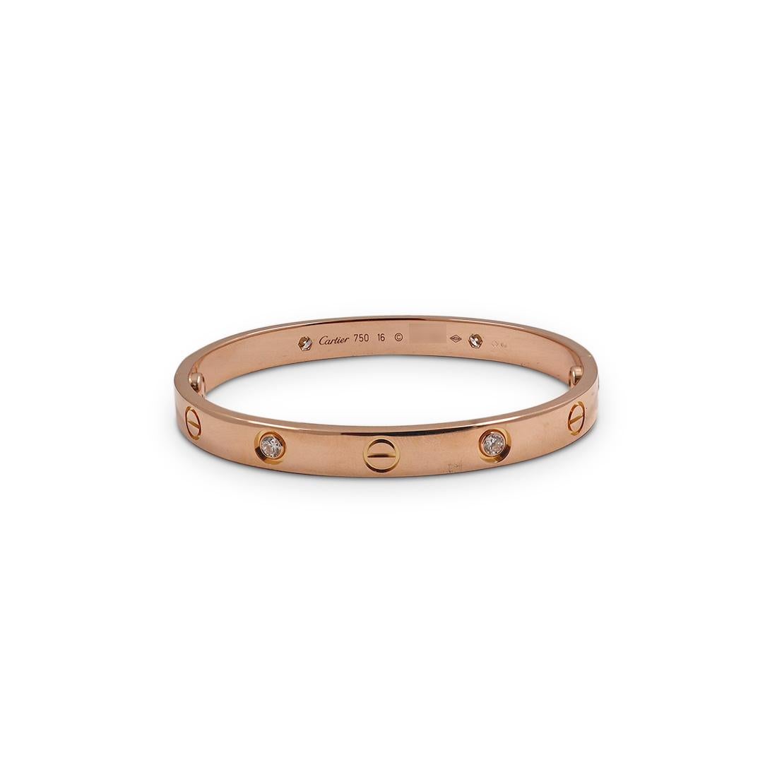 Authentic Cartier 'Love' bangle bracelet crafted in 18 karat rose gold set with four round brilliant cut diamonds (G-H in color, VS clarity) weighing an estimated 0.42 carats total. Signed Cartier, 750, 16, with serial number and hallmarks. The