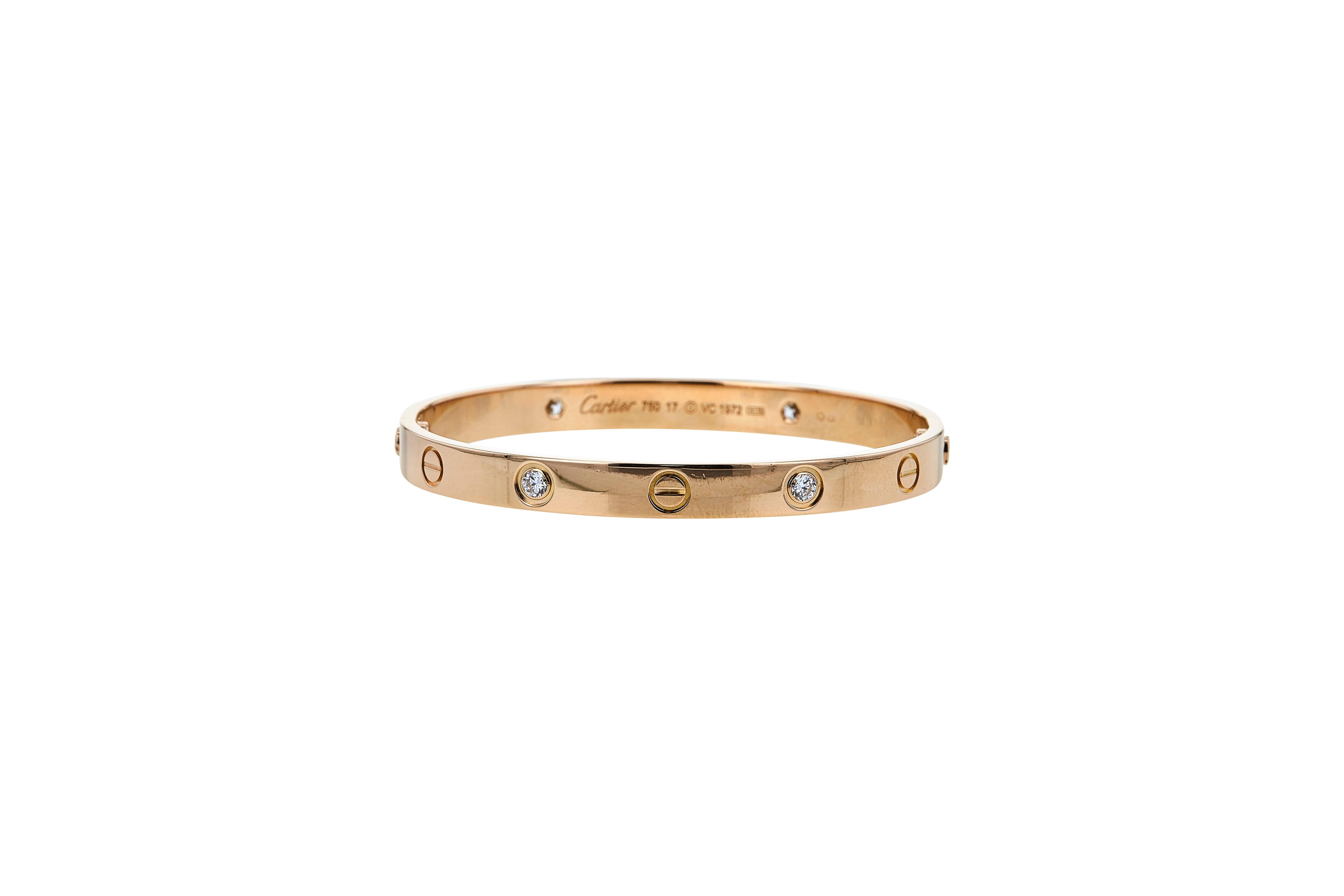 Authentic Cartier 'Love' bracelet crafted in 18 karat rose gold, set with four round brilliant cut diamonds weighing an estimated 0.42 carats total weight. Size 17. Signed Cartier, 750, with serial number and hallmarks. The bracelet is presented