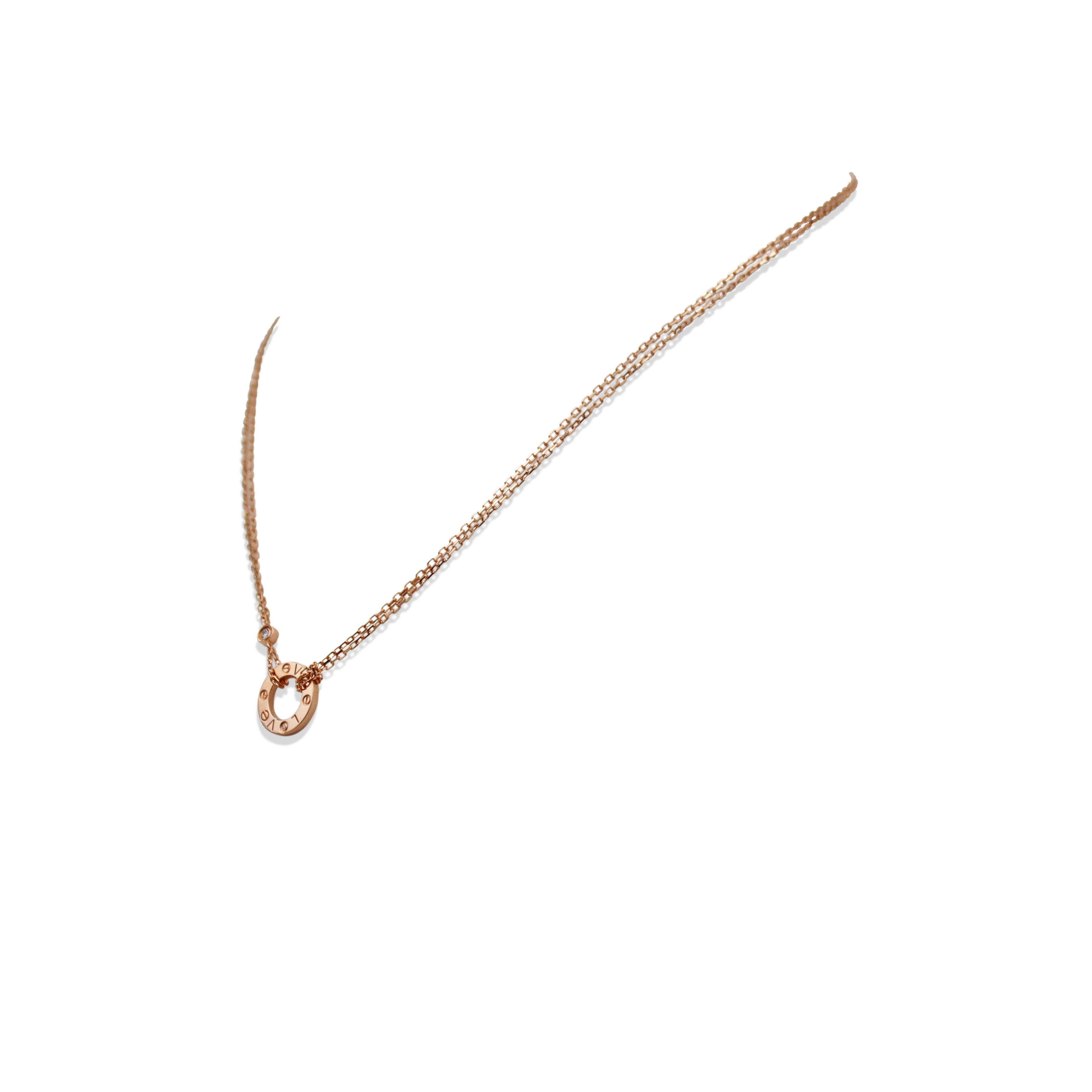 Authentic chain and ring charm necklace from the Cartier 'Love' collection. Crafted in 18 karat rose gold, the double strand oval link chain features a half-inch round ring and screw top motifs set with two round brilliant cut diamonds of