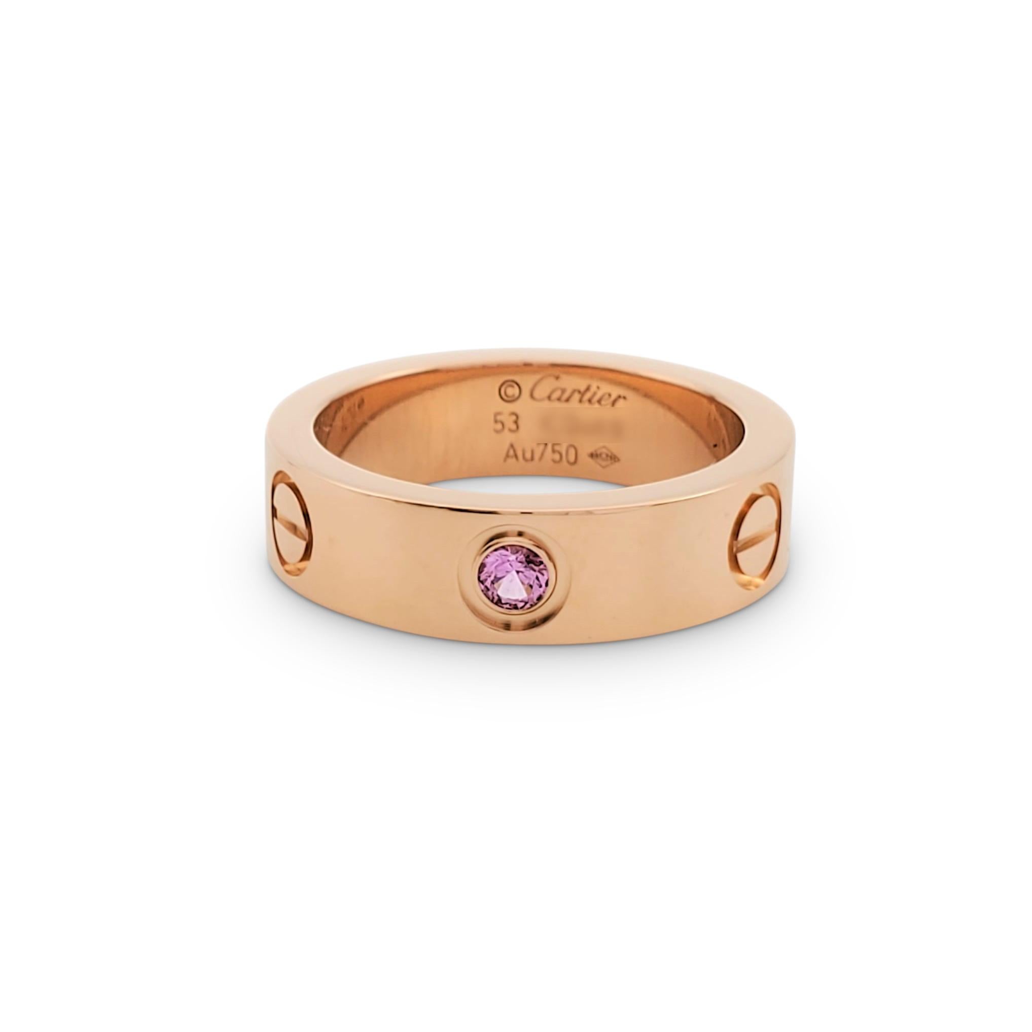 Authentic Cartier 'Love' ring crafted in 18 karat rose gold and set with one round pink sapphire weighing an estimated 0.06 carats. Signed Cartier, 53, Au750, with serial number. Ring size 53 (US 6 1/4). The ring is presented with the original box