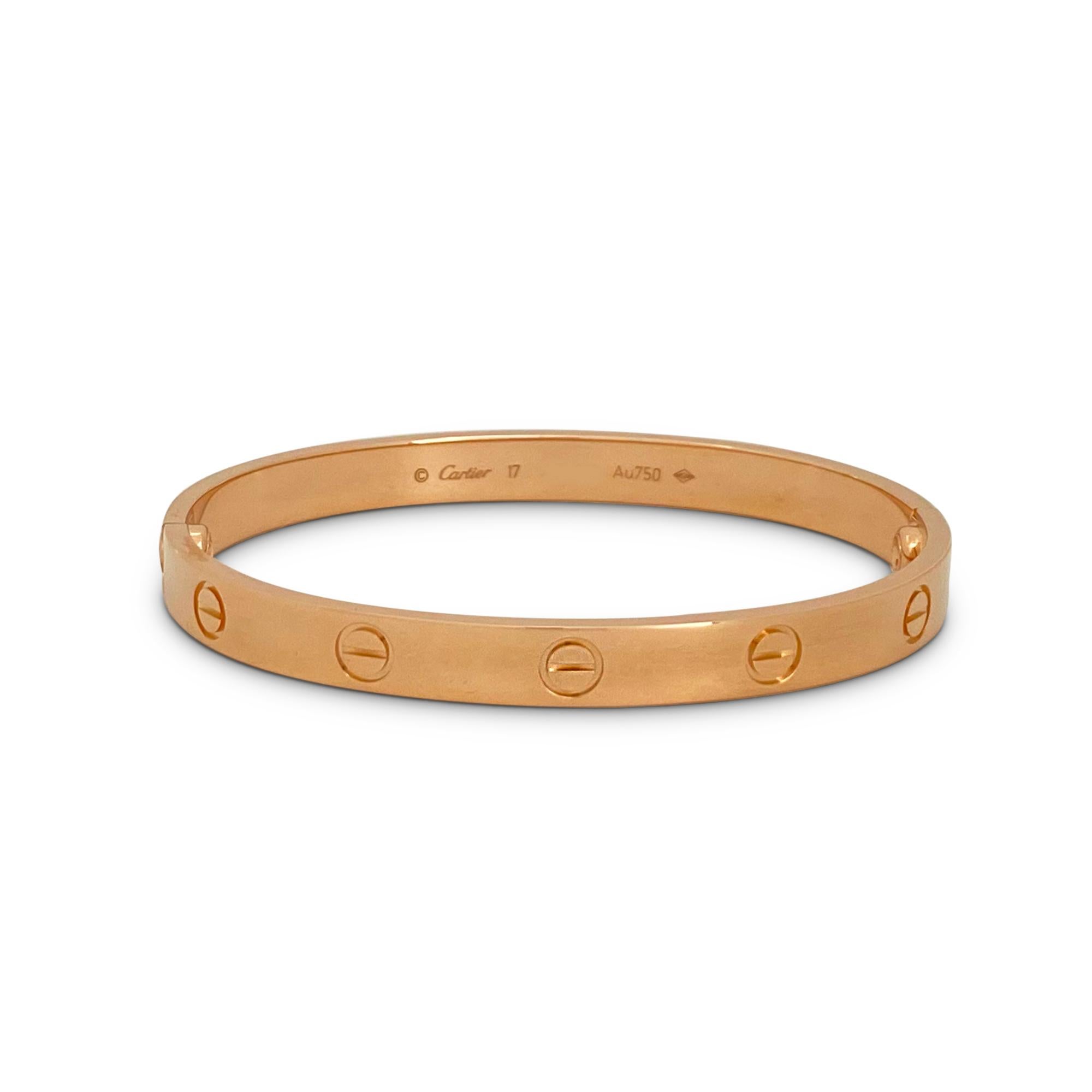 Authentic Cartier 'Love' bracelet crafted in 18 karat rose gold. Size 17. Signed Cartier, 17, Au750, with serial number and hallmarks. New screw system with Cartier enhancement for added security.  The bracelet is presented with a Cartier pouch and