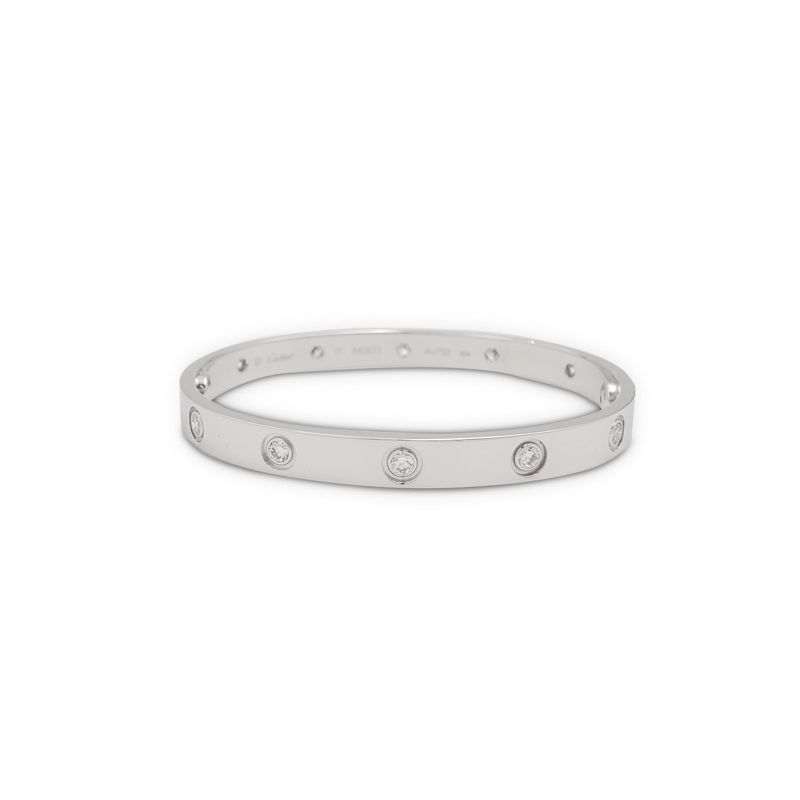 Authentic Cartier 'Love' bracelet crafted in 18 karat white gold is set with ten round brilliant cut diamonds (E-F, VS) weighing 0.96 carats total. Signed Cartier, Au750, 17, with serial number. The bracelet is presented with the original papers,
