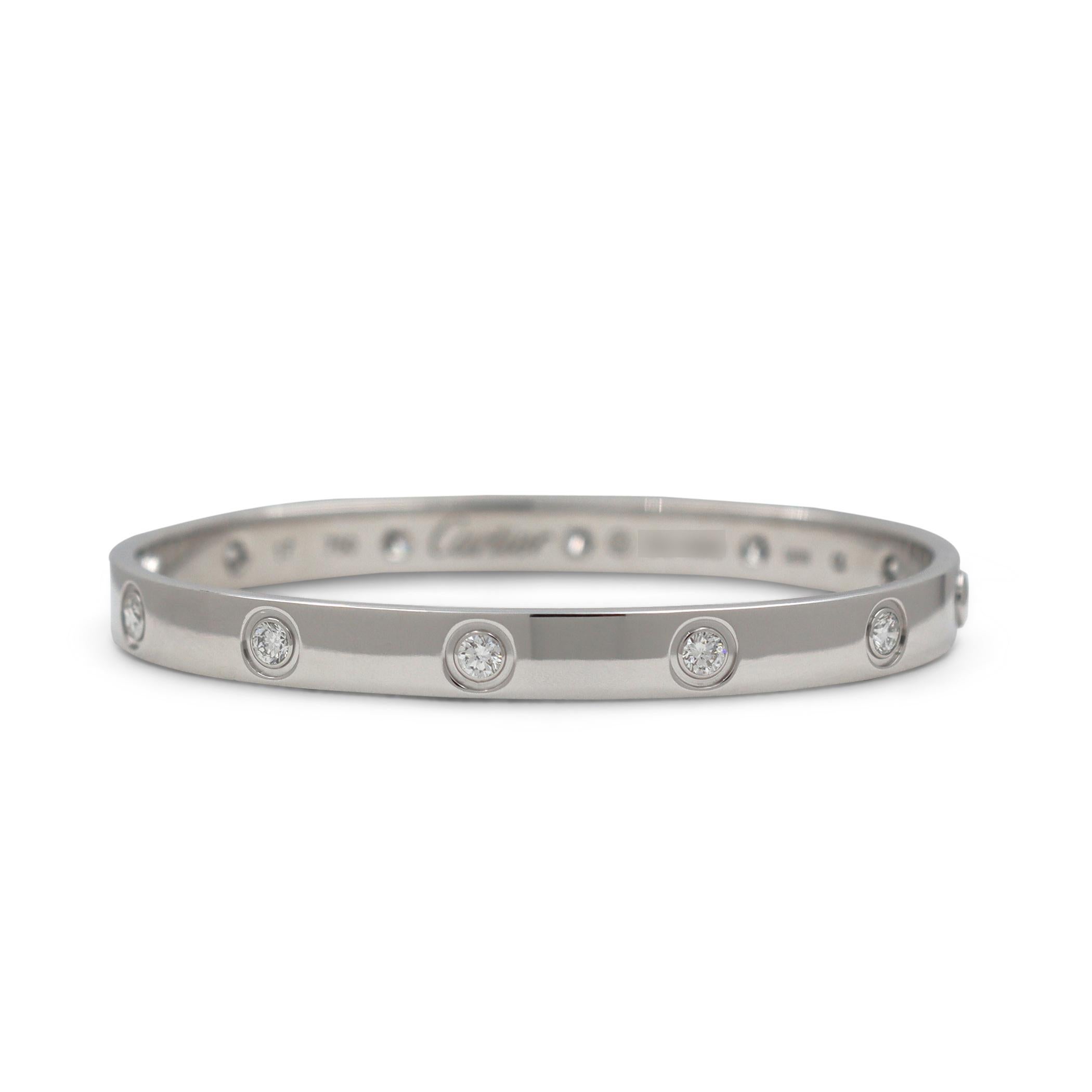 Authentic Cartier 'Love' bracelet crafted in 18 karat white gold and set with ten high-quality round brilliant cut diamonds E-F in color, VS clarity) weighing an estimated 0.96 carats total. Size 17. Signed Cartier, 750, 17, with serial number and