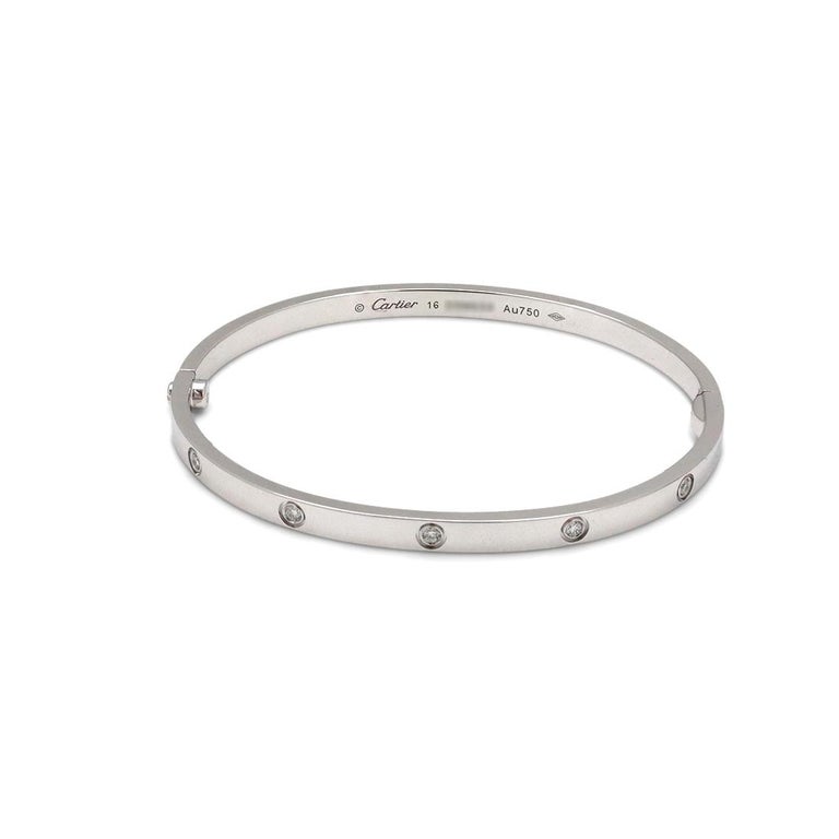Authentic Cartier 'Love' bracelet crafted in 18 karat white gold is set with ten round brilliant cut diamonds (E-F, VS) weighing 0.21 carats total. Signed Cartier, Au750, 16, with serial number and hallmark. The bracelet is presented with the