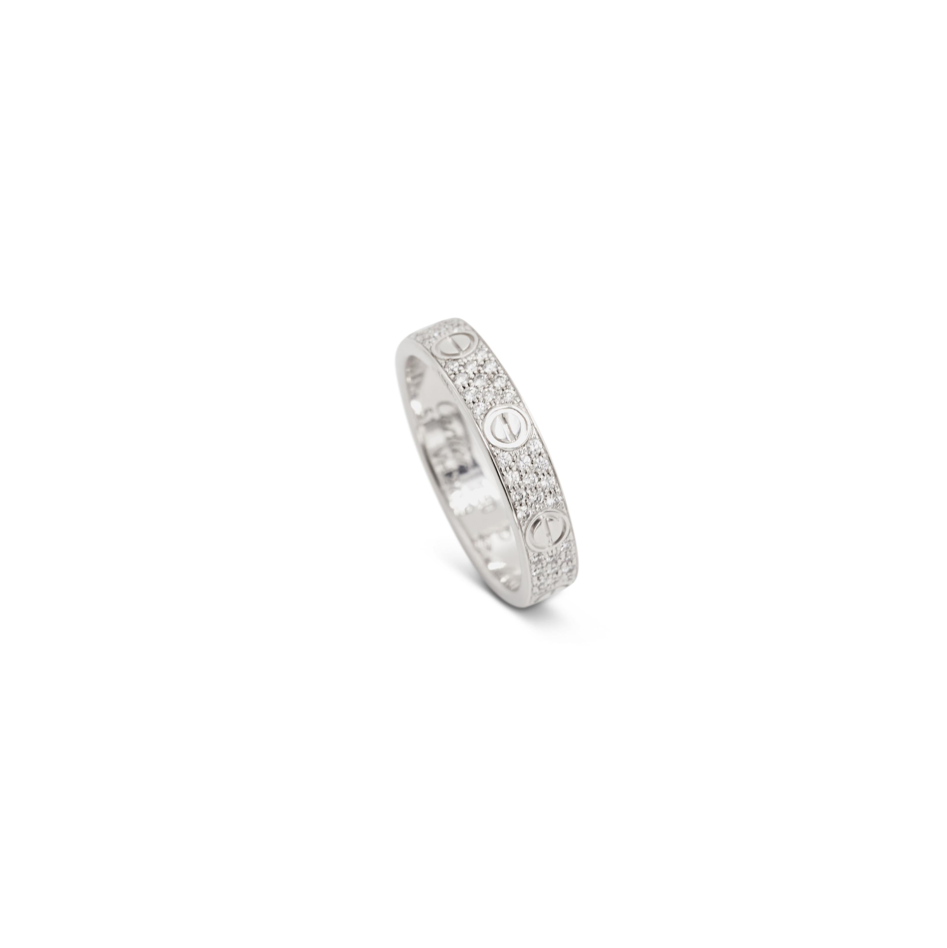 Authentic Cartier ‘Love’ Wedding Band crafted in 18 karat white gold and set with three rows of glittering pave round brilliant diamonds weighing an estimated 0.31 carats. Signed Cartier, 51, Au750, with serial number and hallmarks. Size 51, US 5